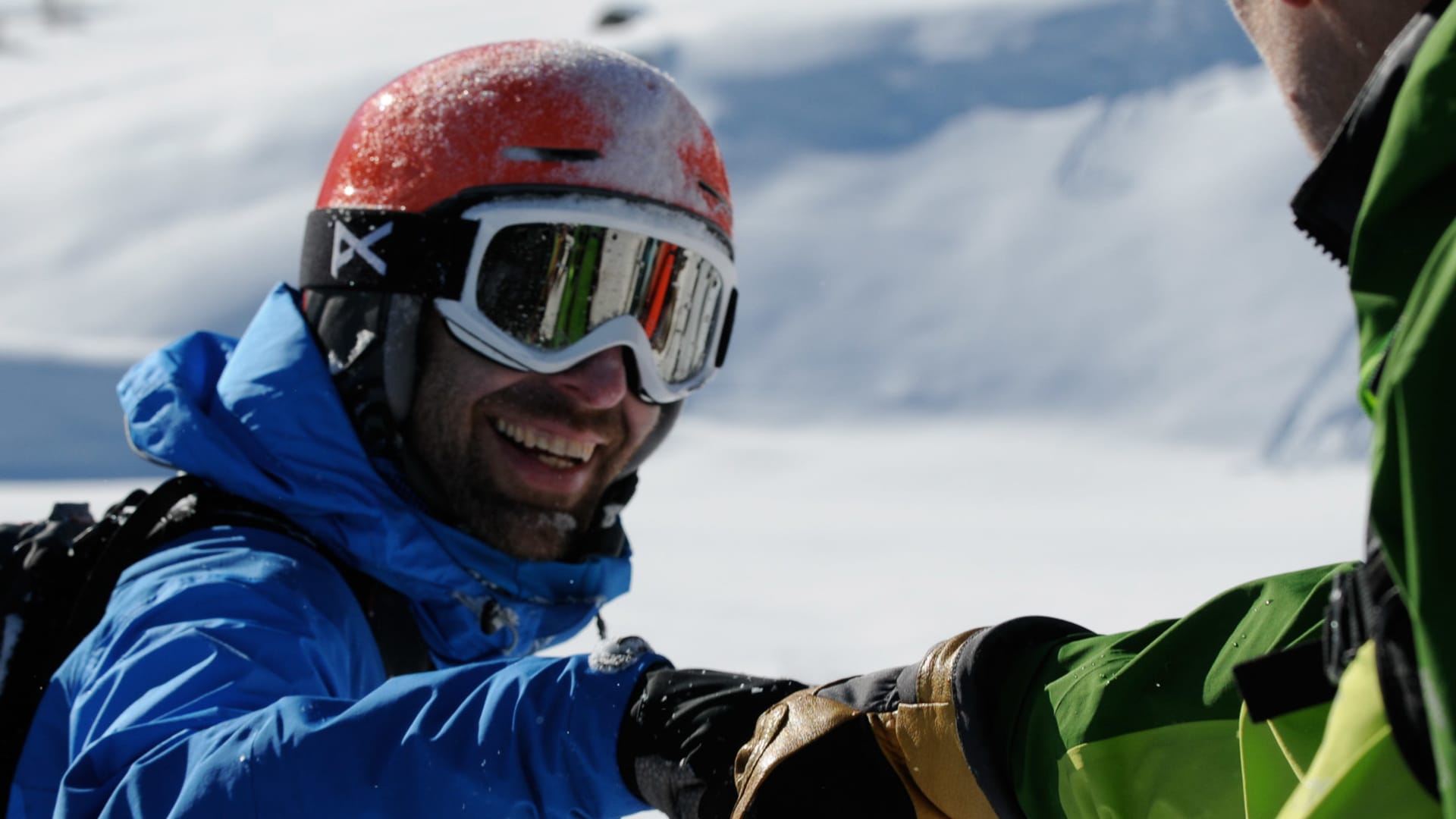 Zwei Freerider in Skijacken und Helmen stoßen nach einer Skitour in Disentis die Fäuste zusammen.
