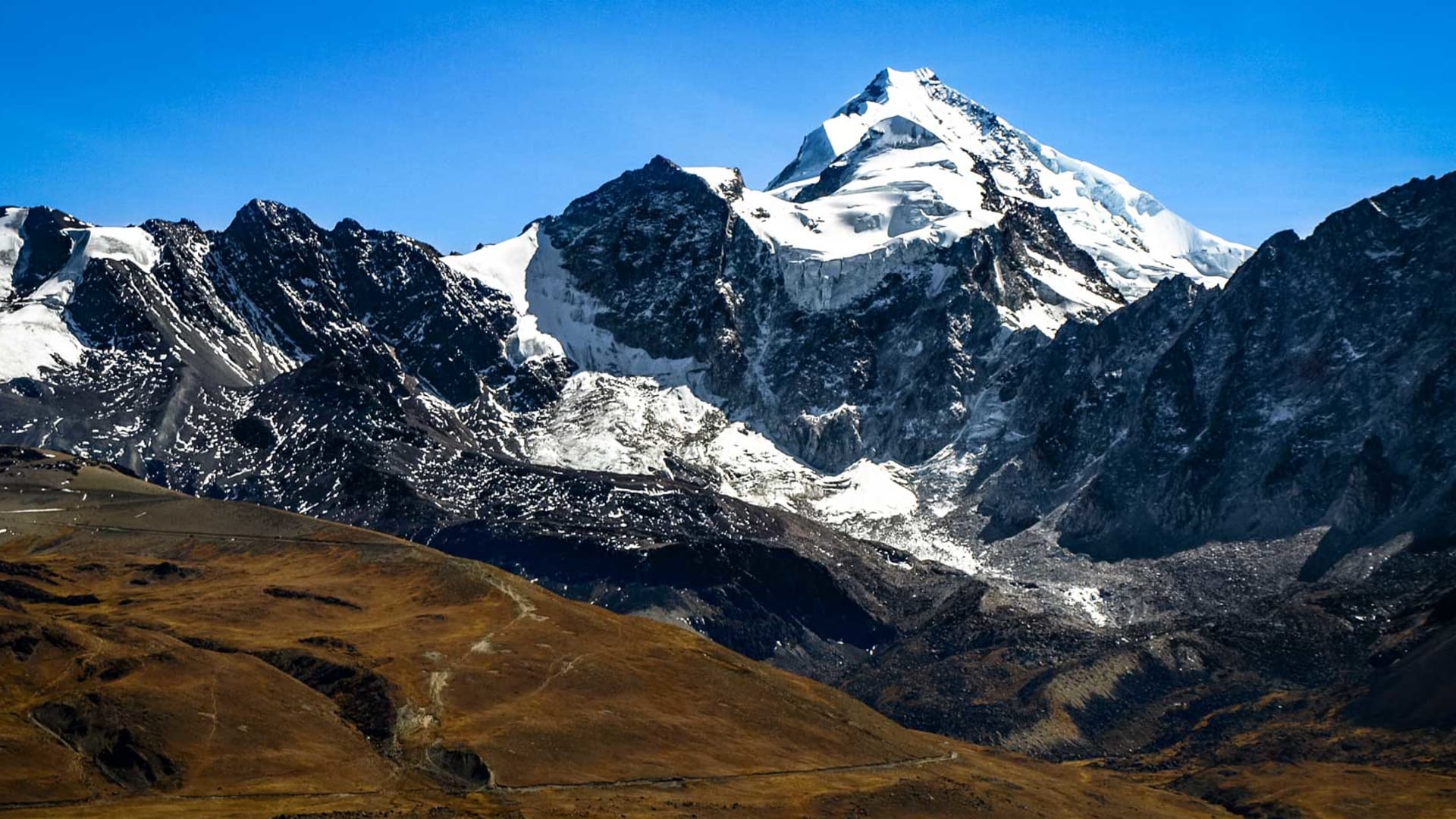 Expedition auf den Huayna Potosi: pyramidenförmiger Gipfel mit Gletscher über dem Hochplateau der Cordillera Real.