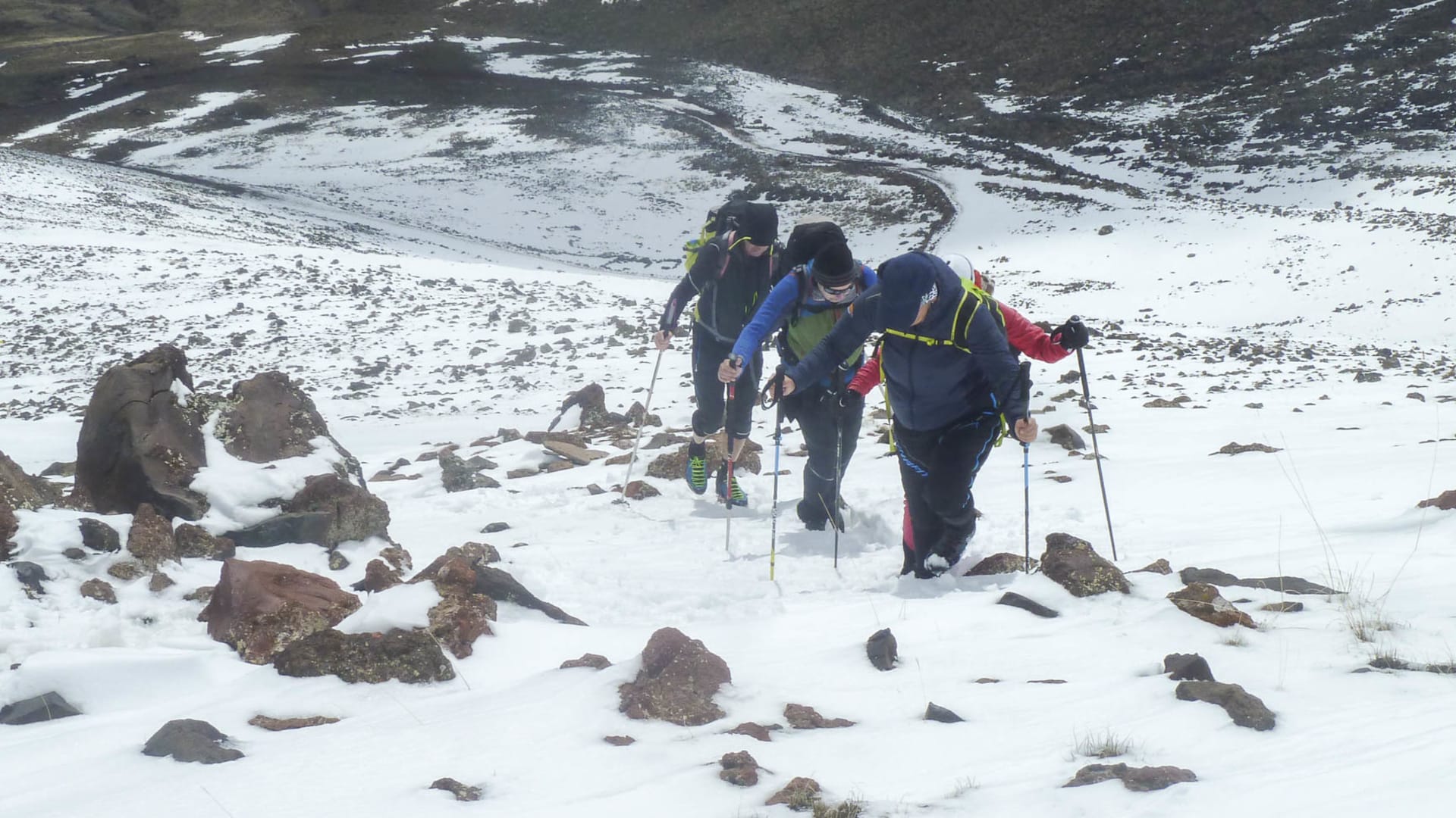 Drei Höhenbergsteiger steigen einen schneebedeckten, felsigen Hang am Ararat in der Osttürkei auf.