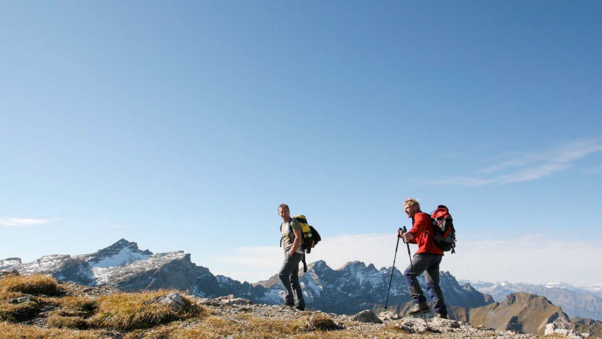 Zwei Bergwanderer auf dem felsig-grasigen Grat am Augstenberg im Fürstentum Liechtenstein.