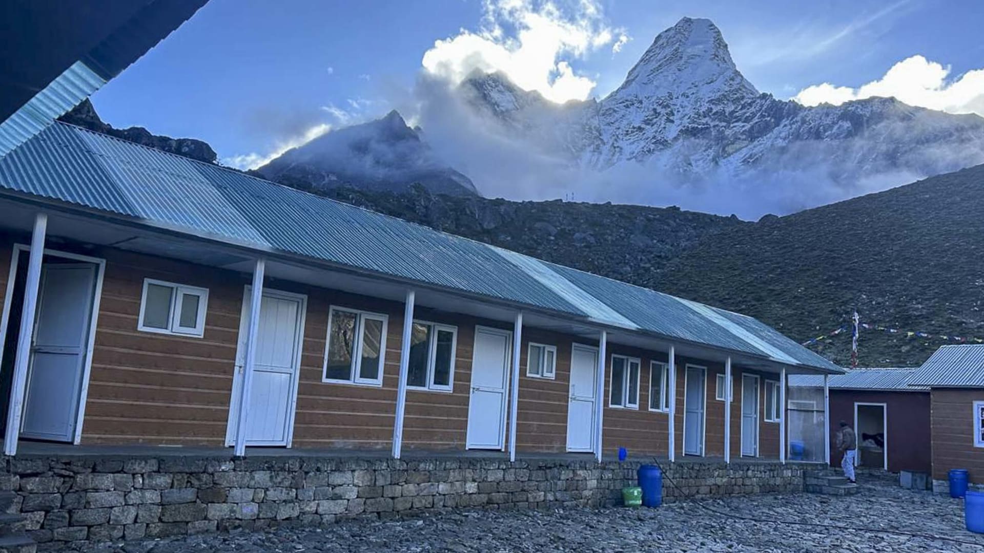Expeditionsgebäude im Basislager bei Chukung mit dem schneebedeckten Ama Dablam als Pyramidengipfel im Hintergrund.