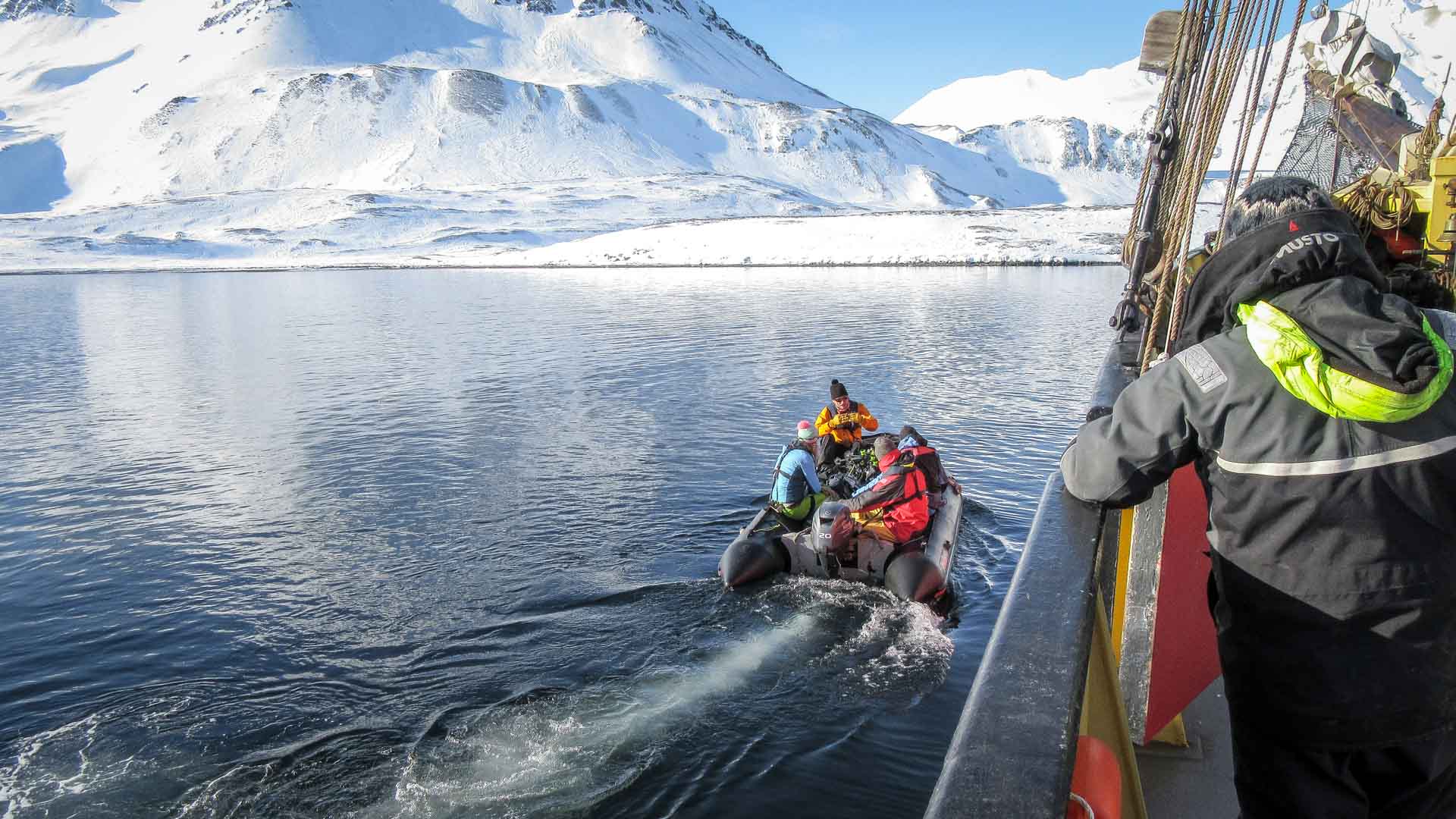 Schlauchboot legt von Expeditionsschiff ab – Professional B2B Szene mit vier Personen in Winterkleidung auf ruhigem Boot