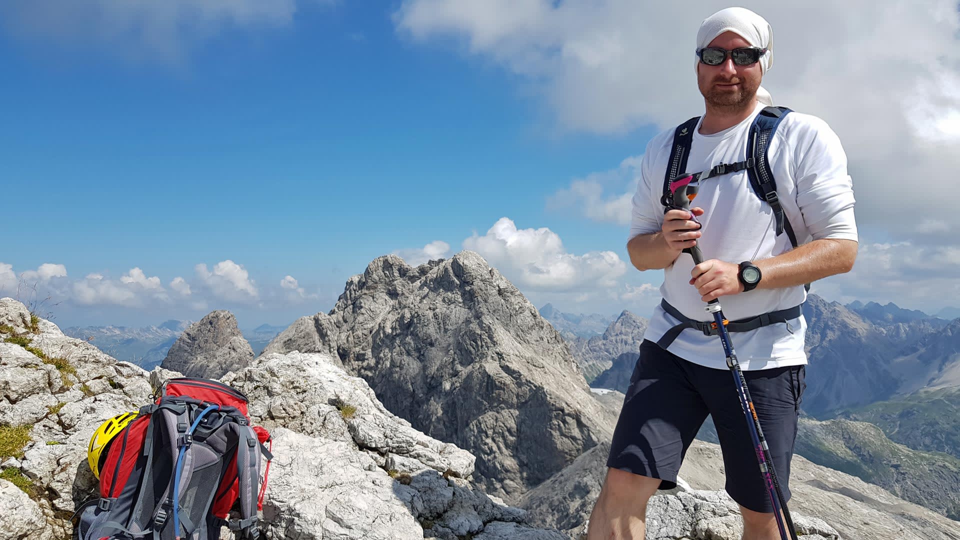 Bergwanderführer Achim Heib mit Wanderstock und Rucksack auf einem Kalkfelsgipfel bei der Bergwanderung auf der Alpenüberquerung E5