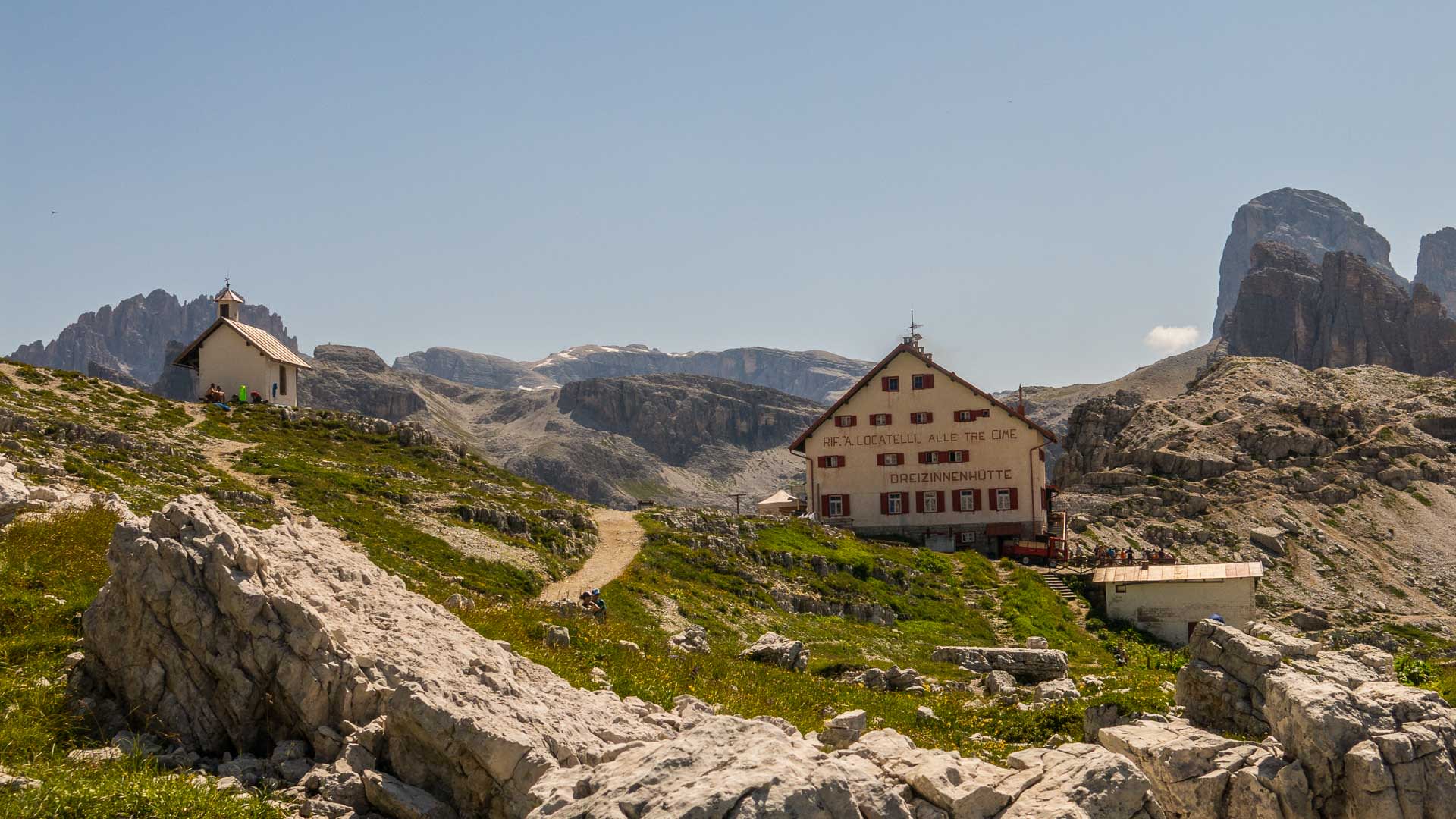 Bergwanderung in den Dolomiten: Dreizinnenhütte (Rif. Locatelli alle Tre Cime) mit kleiner Kapelle, Kalkfelsvordergrund