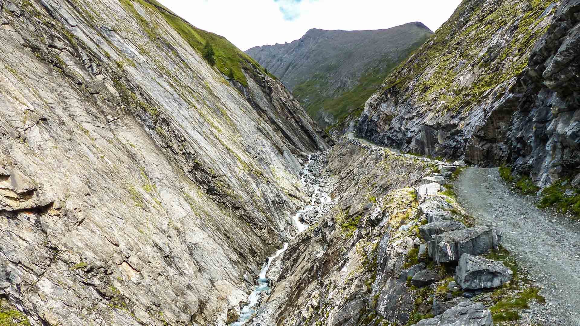 Enge Felsschlucht mit Wildwasserbach und Wanderweg bei der Bergwanderung am Großglockner in den Hohen Tauern.