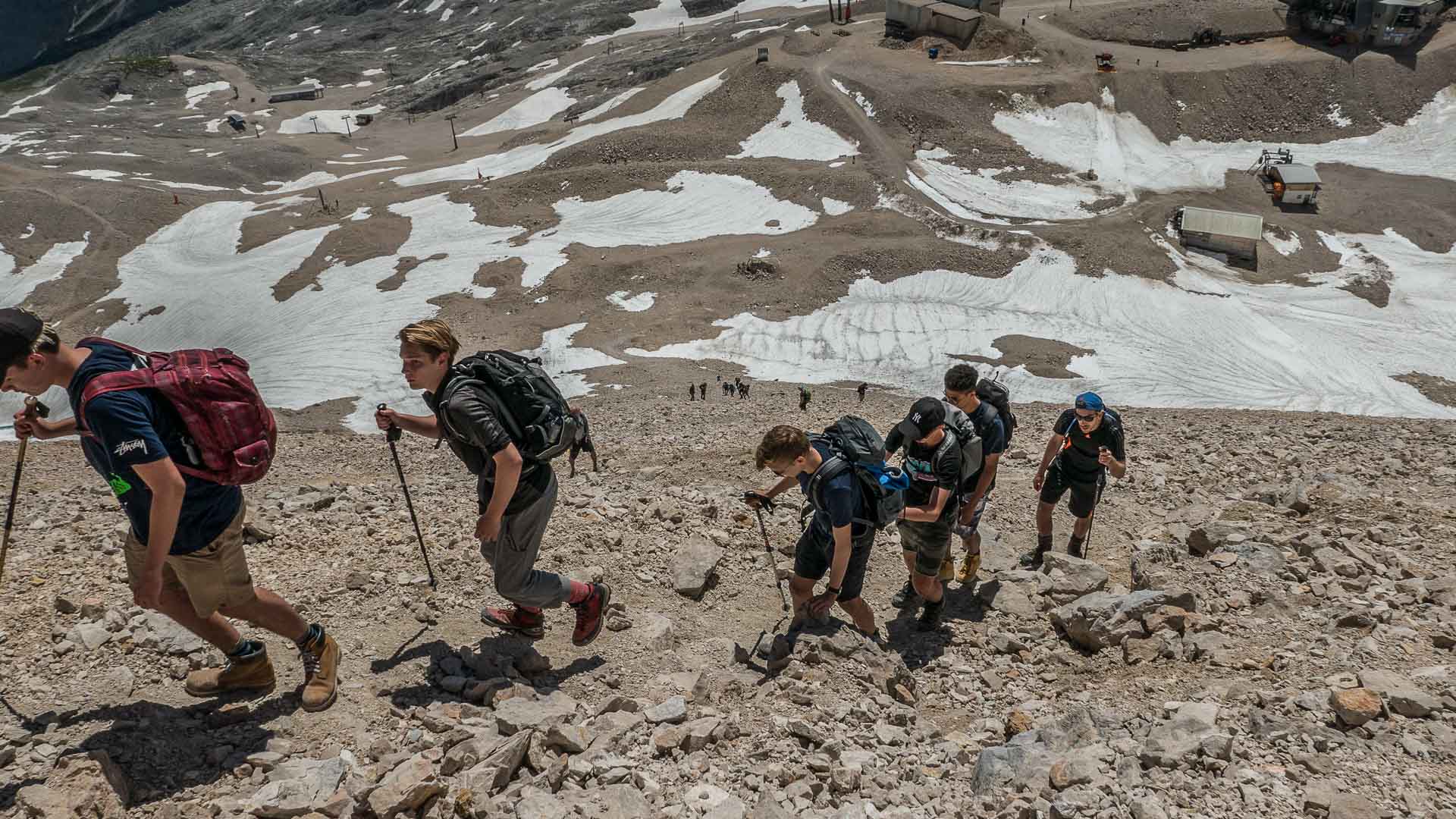 Bergwanderergruppe beim Aufstieg über den Geröllhang kurz vor dem Gipfel der Zugspitze im Sommer.