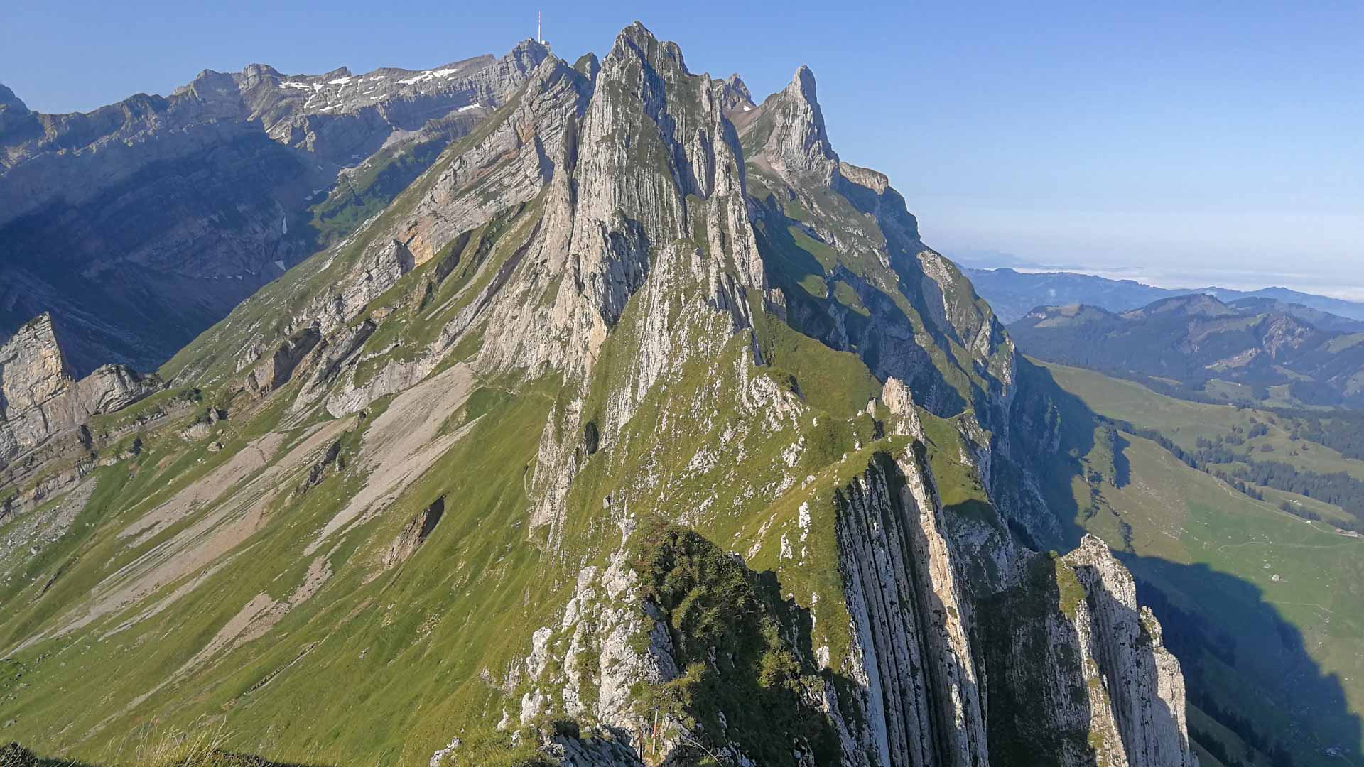 Bergwanderung zu den Altenalptürmen in Appenzell: Felsgrat mit parallelen Kalkfelsrippen und Antenne auf dem Gipfel.