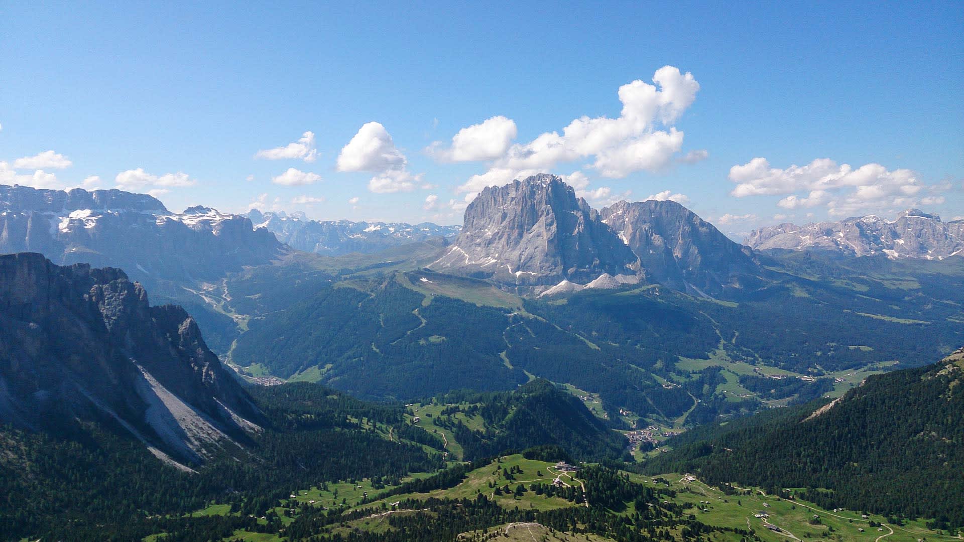 Panoramablick auf das Sellamassiv mit Plateauform und grünem Tal bei einer Bergwanderung in den Dolomiten.