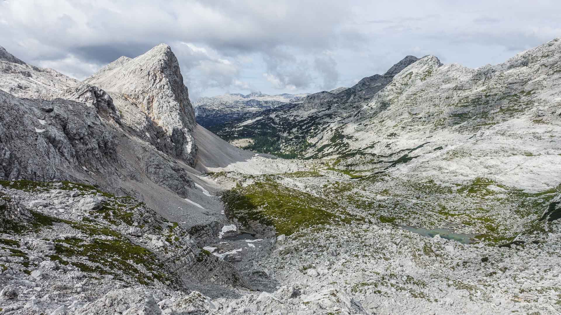 Bergwanderung ins Sieben-Seen-Tal: Karplateau mit türkis-grünem Bergsee und Kalkgipfel im Sommer.