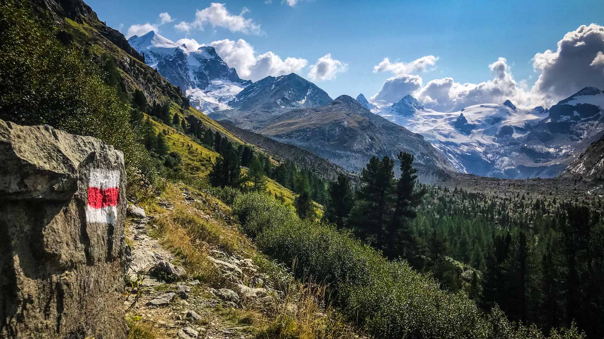 Bergwanderung auf dem markierten Wanderweg zur Tschiervahütte mit Blick auf vergletscherte Gipfel der Bernina-Alpen.
