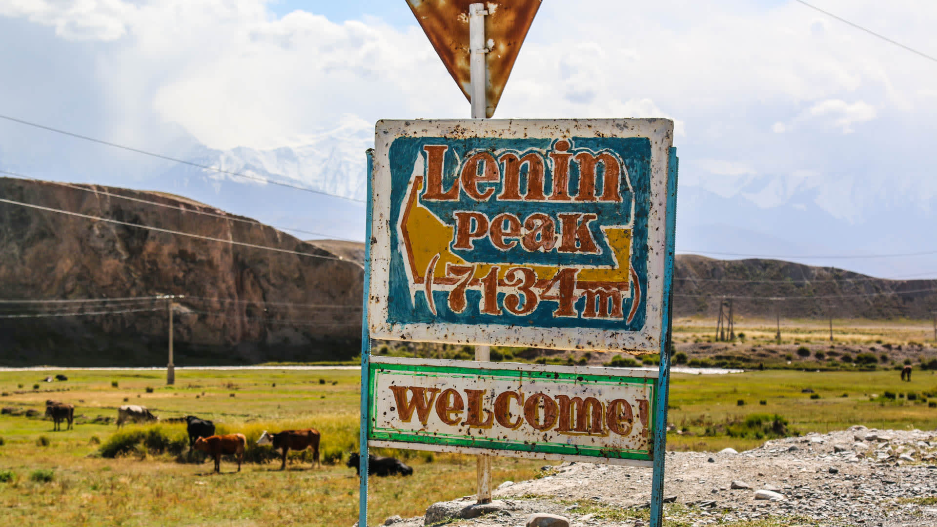 Verwittertes Straßenschild mit Aufschrift Lenin Peak 7134m am Eingang zum Basislager im Pamir.