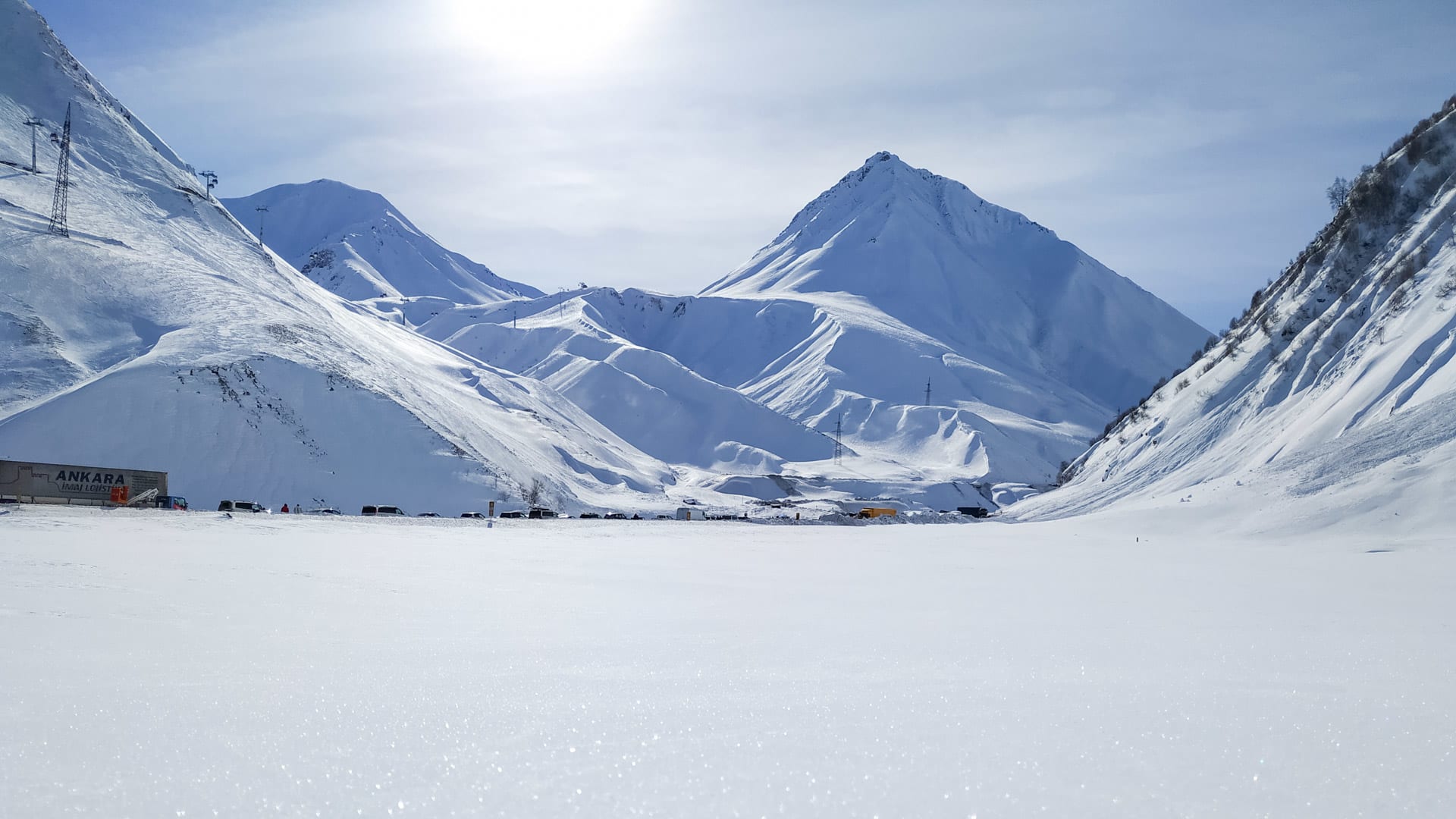 Expedition Kazbek: verschneites Hochtal bei Gudauri mit pyramidenförmigem Gipfel im Hintergrund.