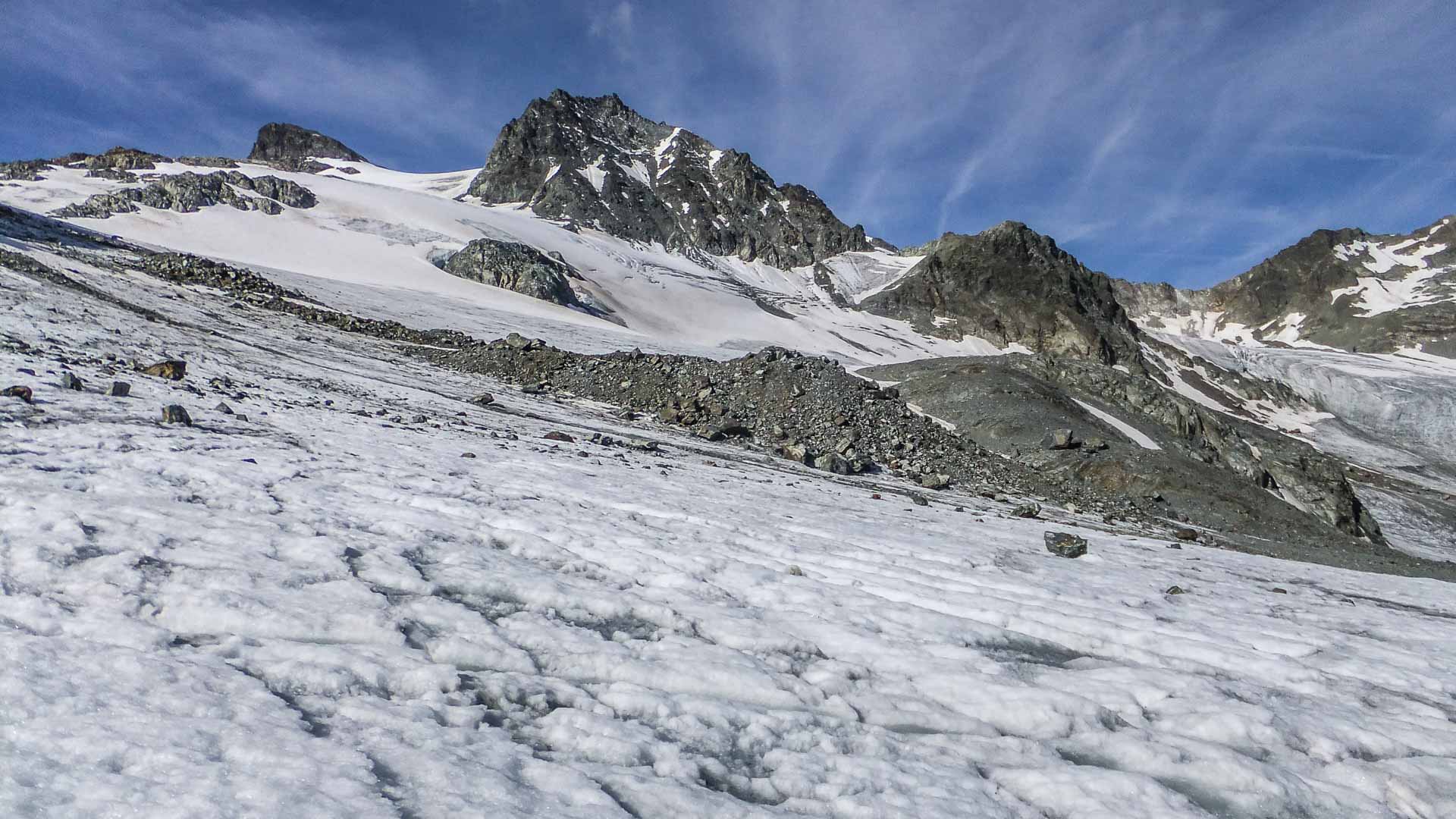 Hochtour in der Silvretta zur Dreiländerspitze: zerklüftetes Gletschereis mit Moränenrücken und felsigem Gipfel