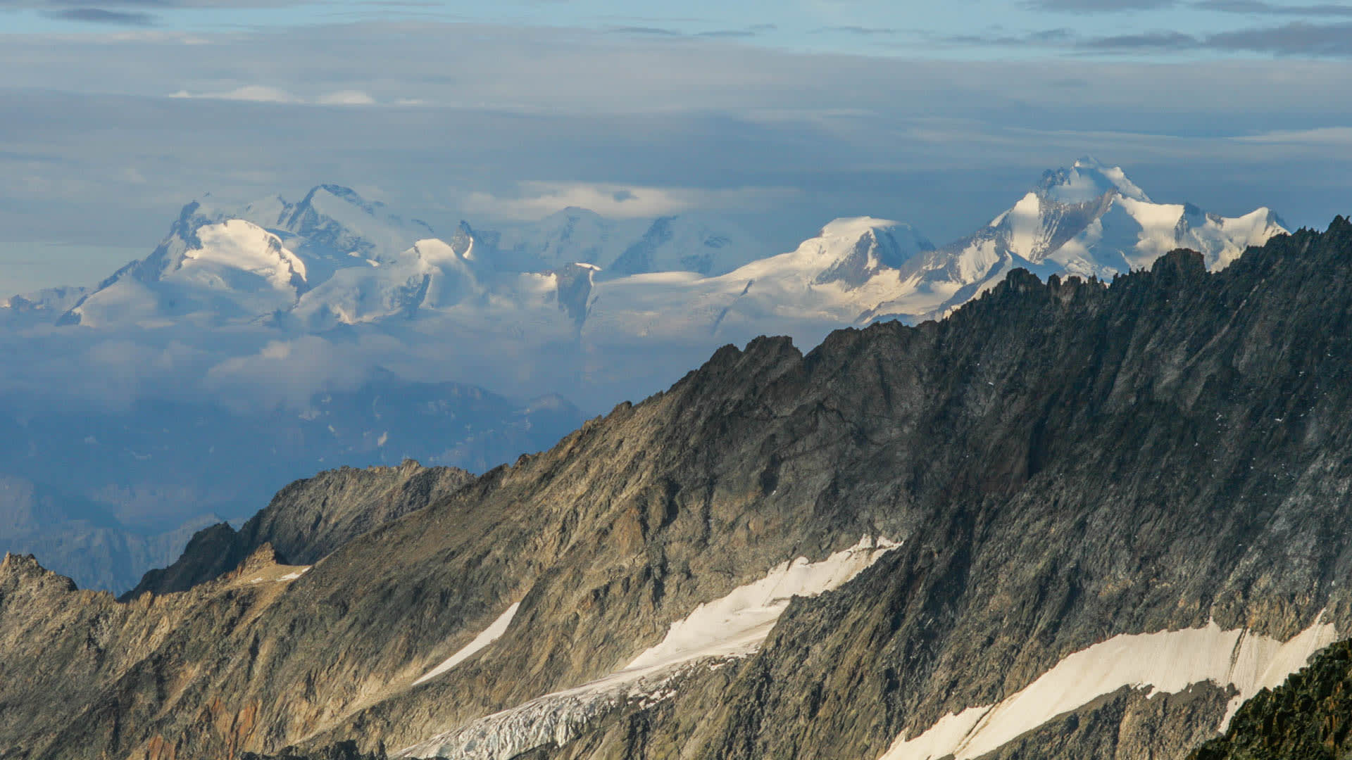 Hochtour am Aletschgletscher: zerklüfteter Felsgrat im Vordergrund, vergletscherte Hochgipfel und Walliser Täler im Hintergrund.