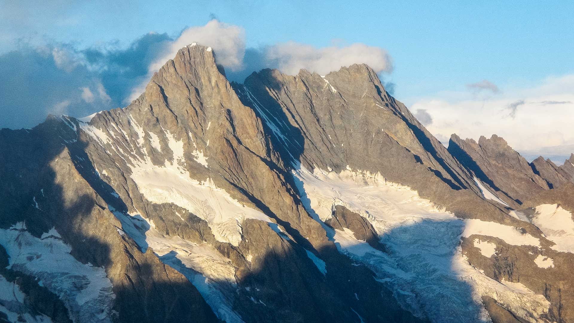 Hochtour auf das Schreckhorn: pyramidenförmiger Gipfel mit Gletscherzunge im Abendlicht der Berner Alpen.