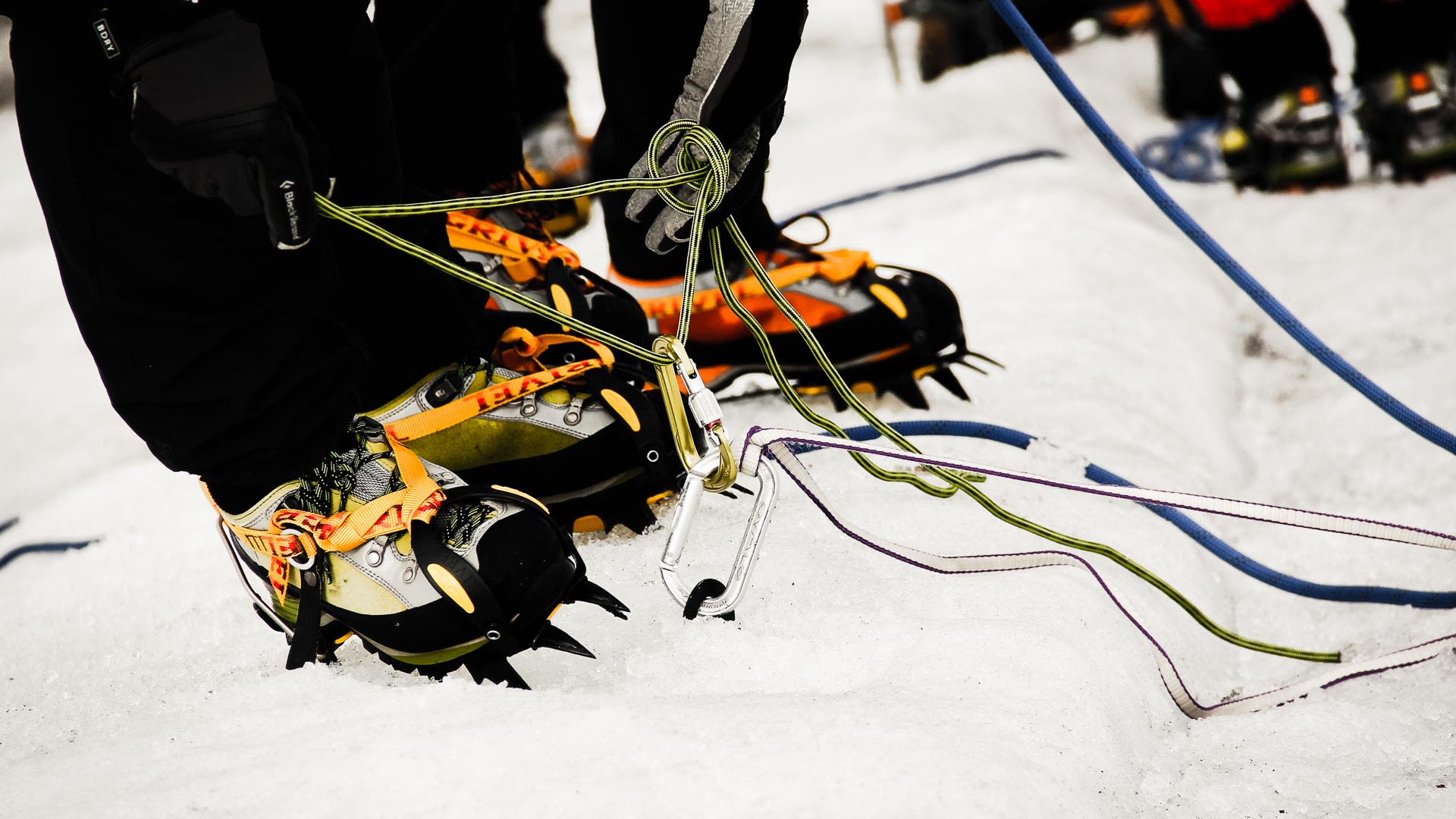 Hochtour Spaltenbergung: Steigeisen mit Frontzacken, Karabiner und farbige Seile auf Schnee beim Hochtourenkurs mit Bergführer