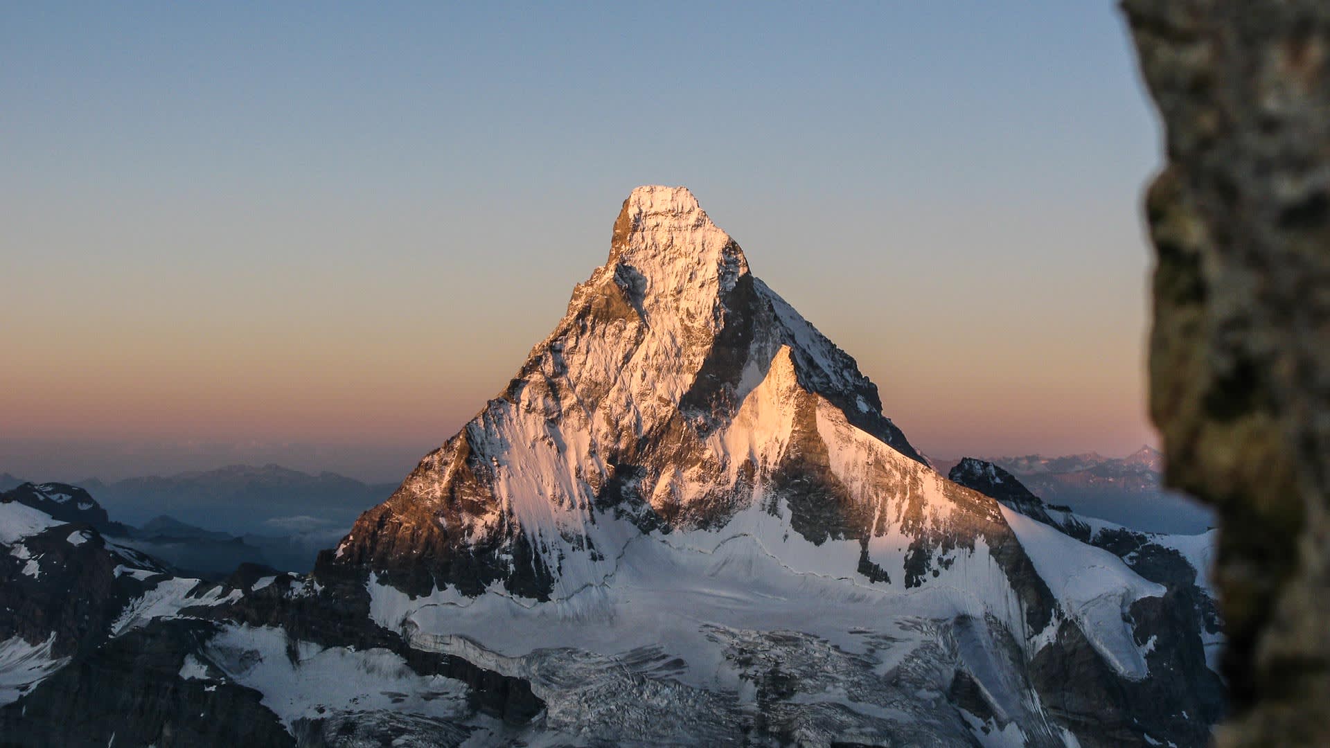 Hochtour im Wallis: Blick vom Obergabelhorn auf das pyramidenförmige Matterhorn im Abendlicht mit Gletscherflanken.