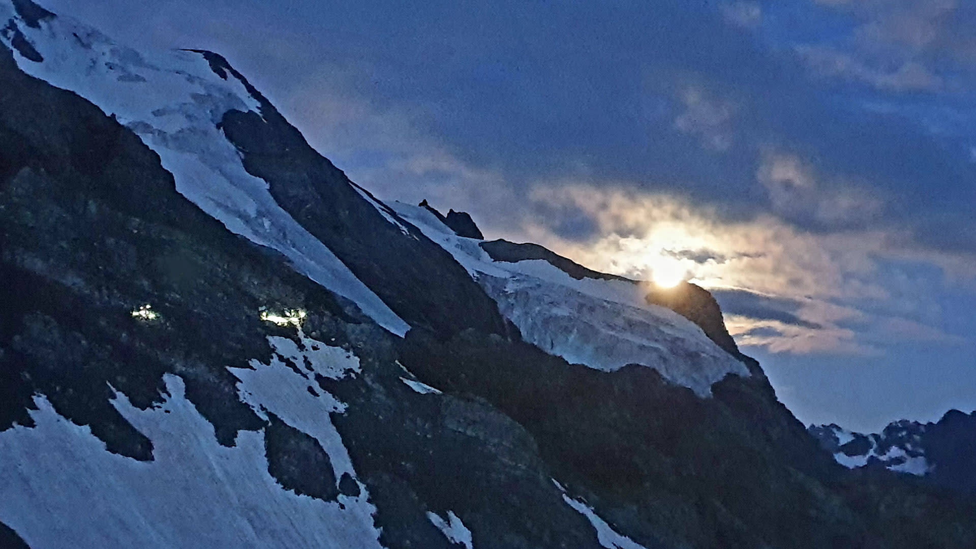 Hochtour am Ortler: Gletscher- und Eisfelder des Ortler-Massivs in der Dämmerung mit leuchtenden Stirnlampenpunkten nahe