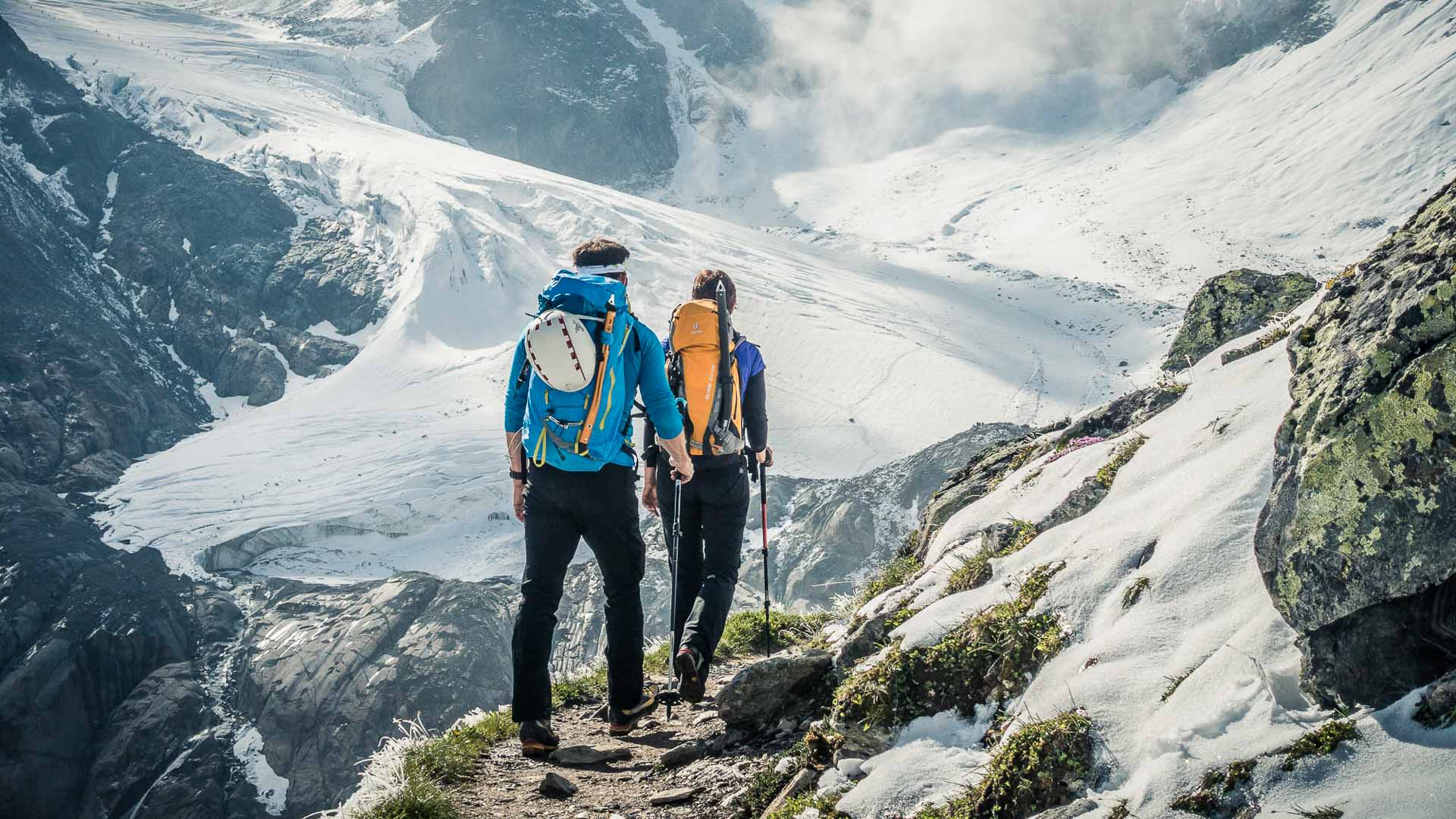 Zwei Bergsteiger gehen auf Felsweg zum Gletscher im Hochtourenkurs in den Ötztaler Alpen.
