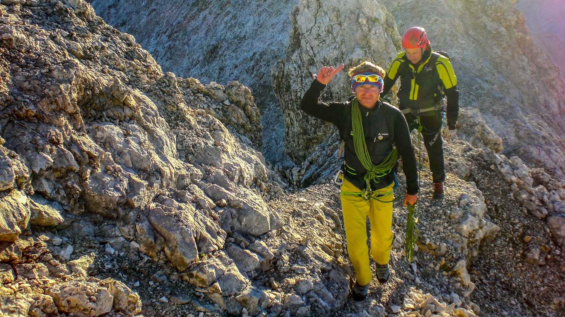 Zwei Kletterer mit Seil und Gurt auf dem Blassengrat im Wettersteingebirge, sonniges Kalkfelsgelände im Morgenlicht.