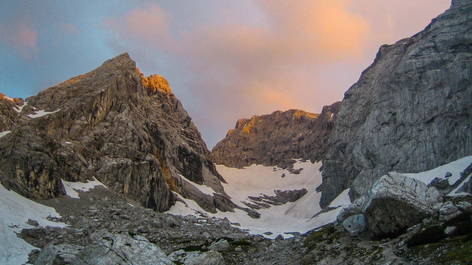 Hochalpines Kar mit Kalkfelswänden, Schneefeldern und Geröll am Blaueisgletscher bei Berchtesgaden im Sommer.
