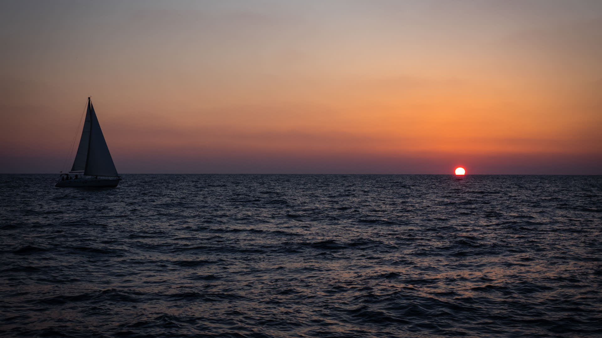 Segelboot als Silhouette bei Sonnenuntergang vor Kalymnos, Klettern und Segeln auf der griechischen Insel