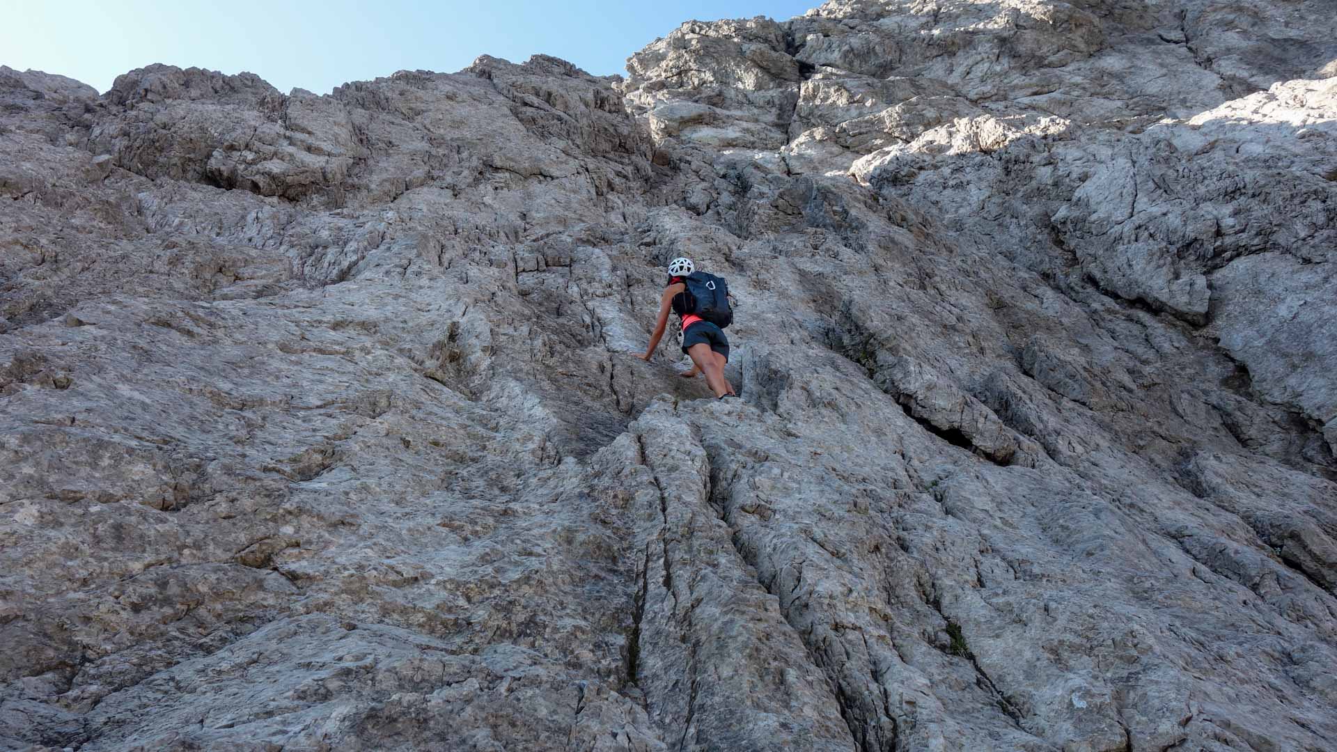 Kletterer steigt in Froschperspektive durch die Wasserrinnen des NW-Grats der Trettachspitze im Allgäu.