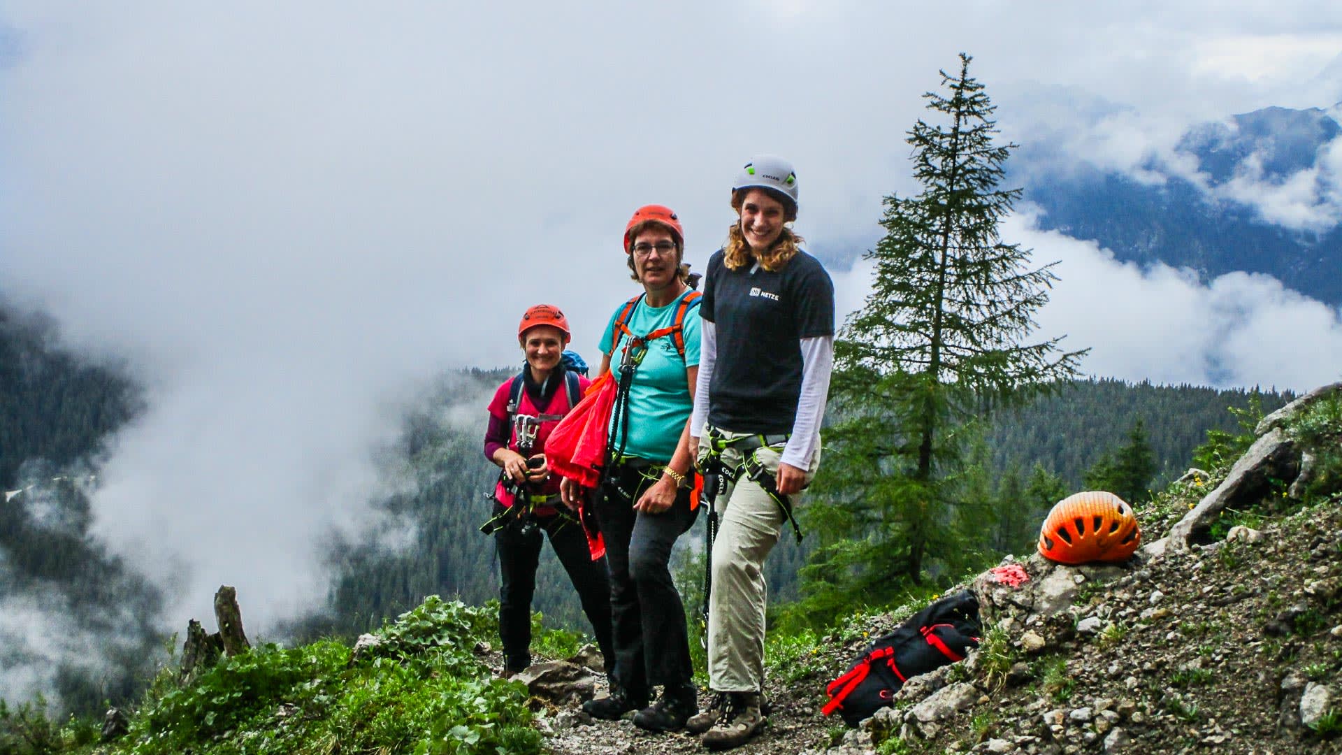Klettersteig Zugspitze: drei Klettersteiggeher mit Helm und Klettergurt posieren am Hang bei der Wiener Neustädter Hütte.