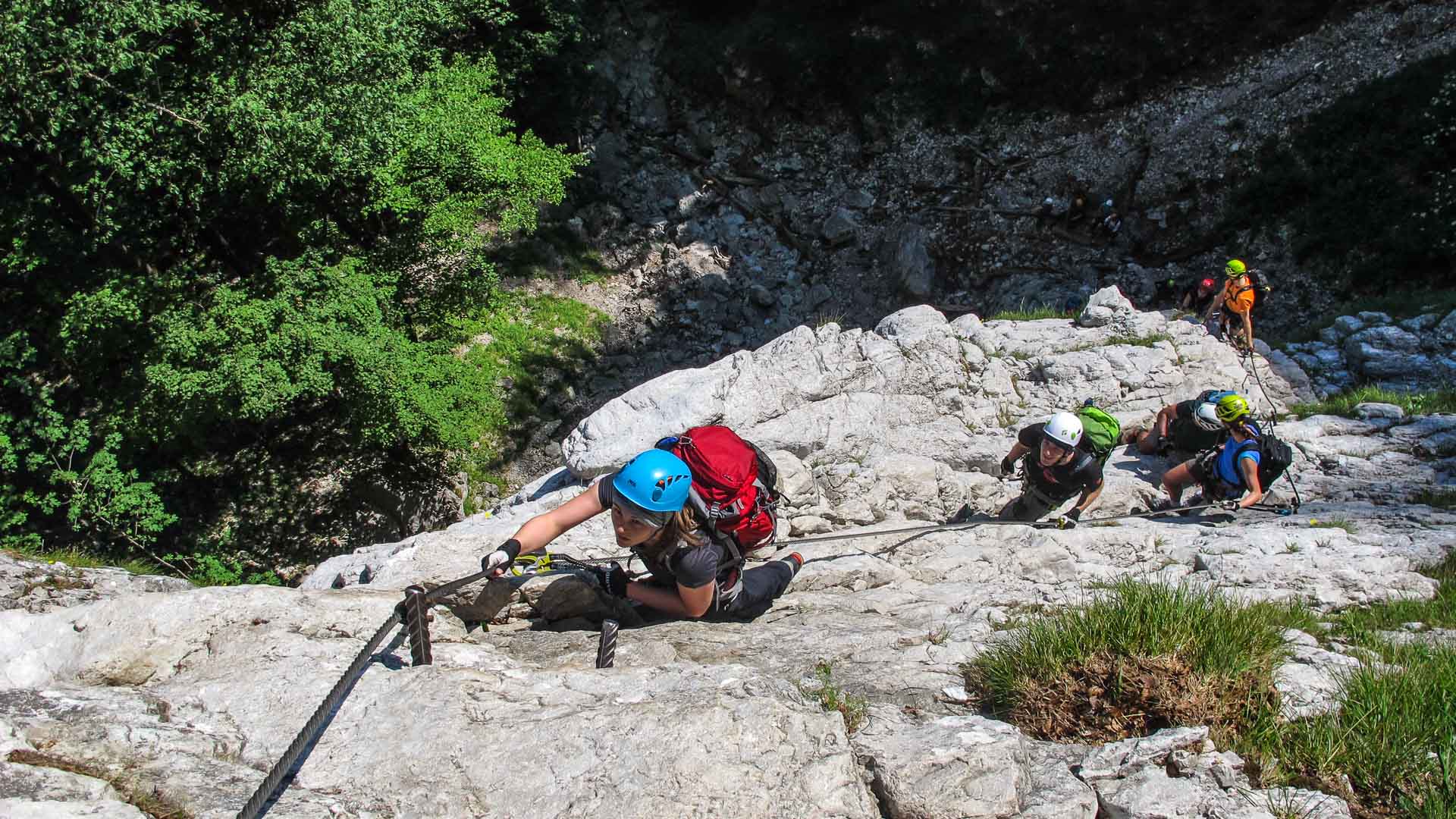 Klettersteigkurs Berchtesgaden: Gruppe klettert an Stahlseil und Trittstiften über hellen Kalkfels aufwärts.