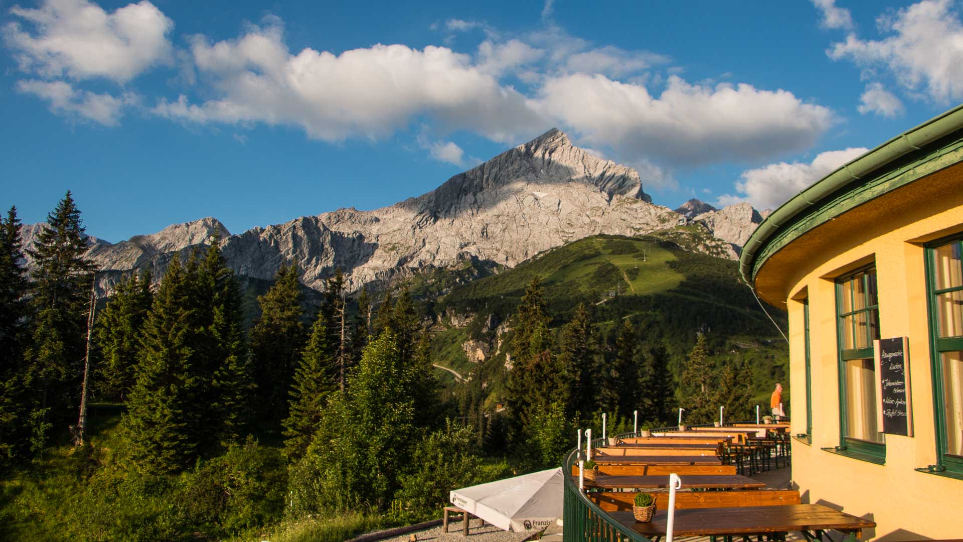 Klettersteig-Stützpunkt Kreuzeckhaus in Garmisch mit Blick auf das Alpspitze-Massiv im Sommer.