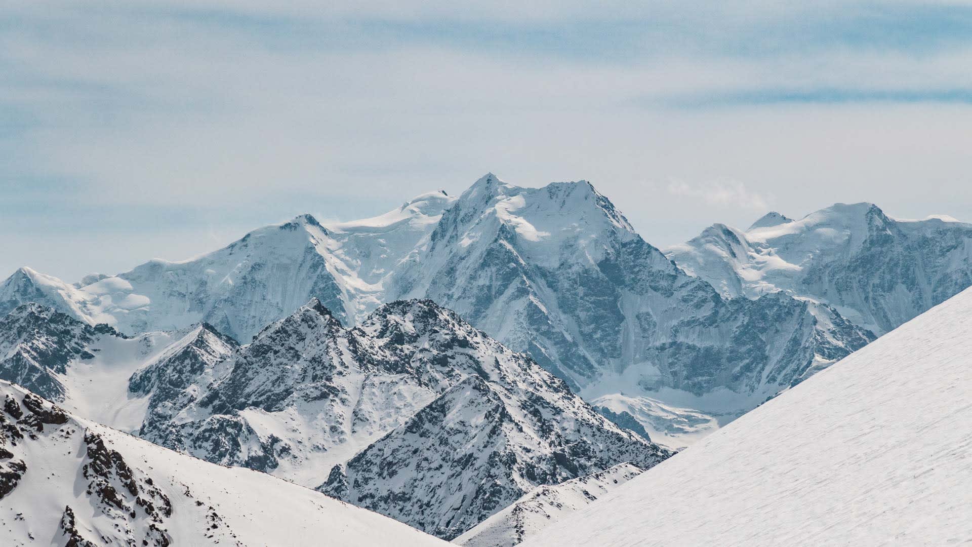 Skitour im Himmelsgebirge Kirgistan: Panorama verschneiter 5000er-Gipfel mit Gletscherfeldern und felsigen Graten