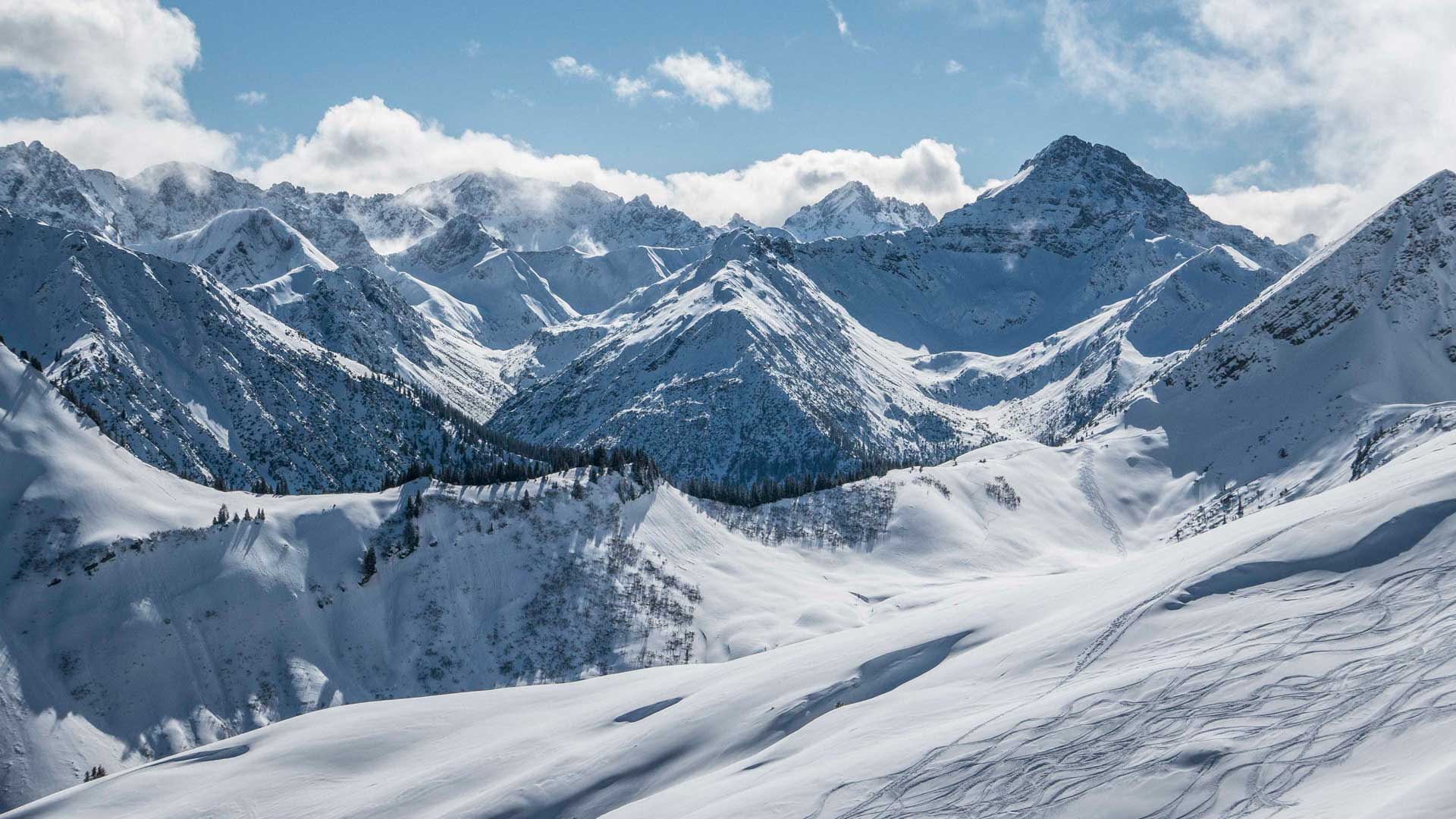 Skitour in den Lechtaler Alpen: verschneiter Steilhang mit Skispuren vor dem Panorama von Abendspitzenamloser und Wetterspitze