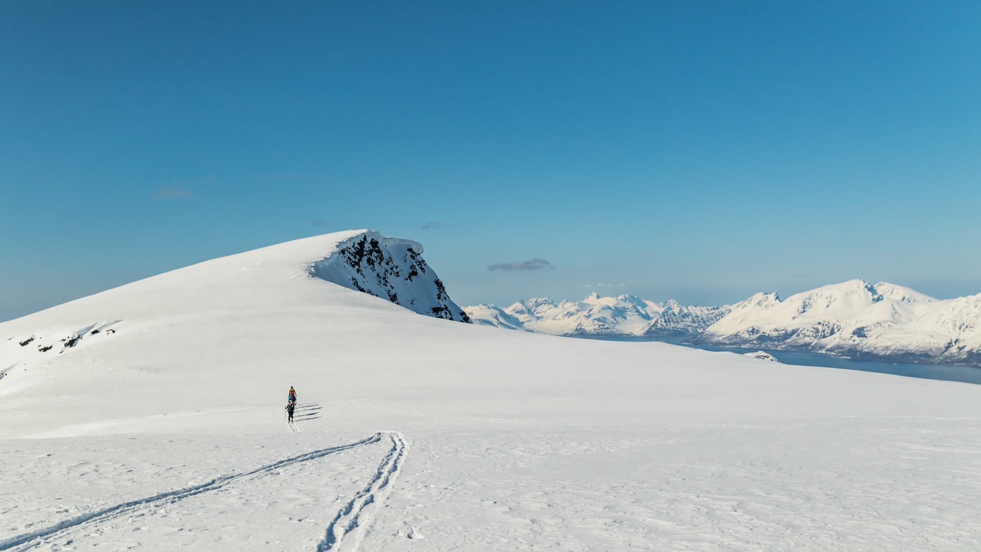 Einzelner Skitourengeher mit Fellen beim Aufstieg auf einem Hochplateau im Skitourengebiet Lyngen nahe Tromsø.