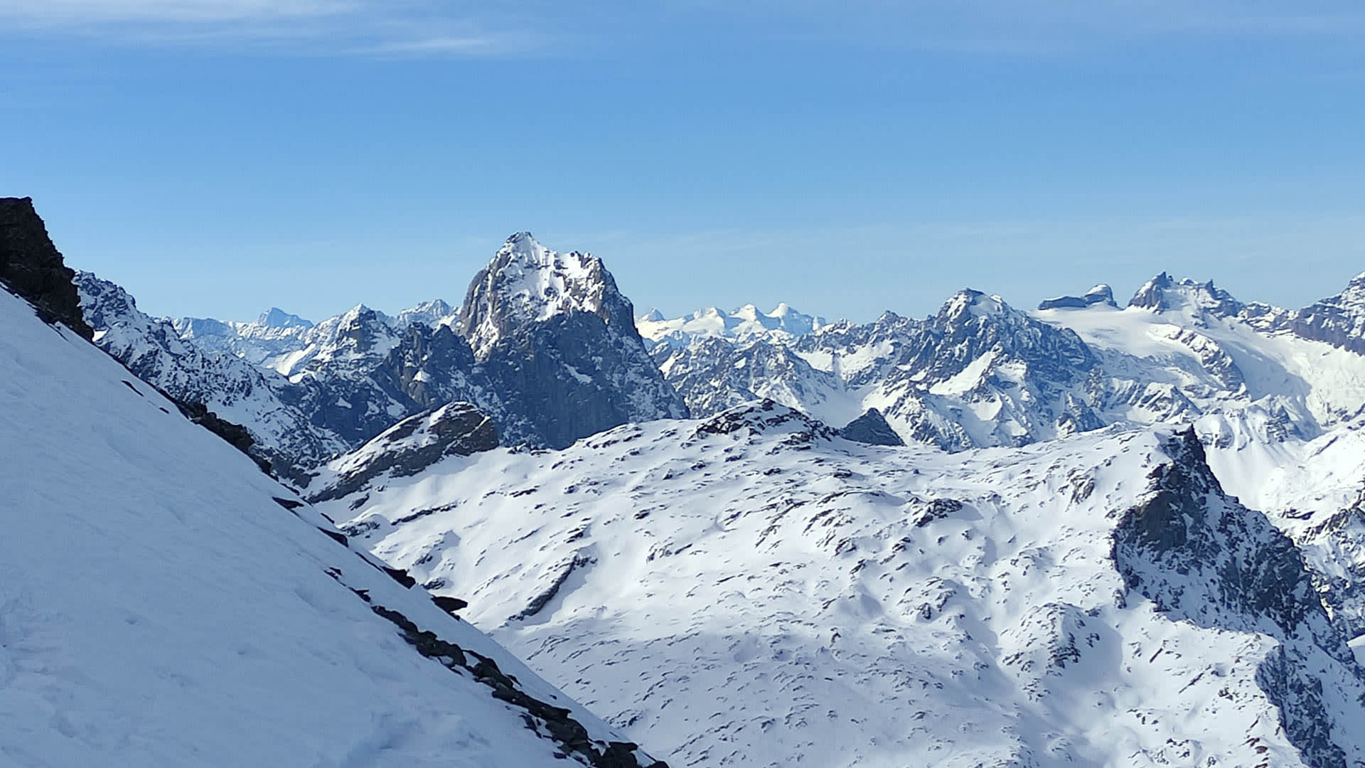 Skitour am Clariden: Blick über ein hochalpines Gletscherplateau auf die verschneite Gipfelkette im Hintergrund