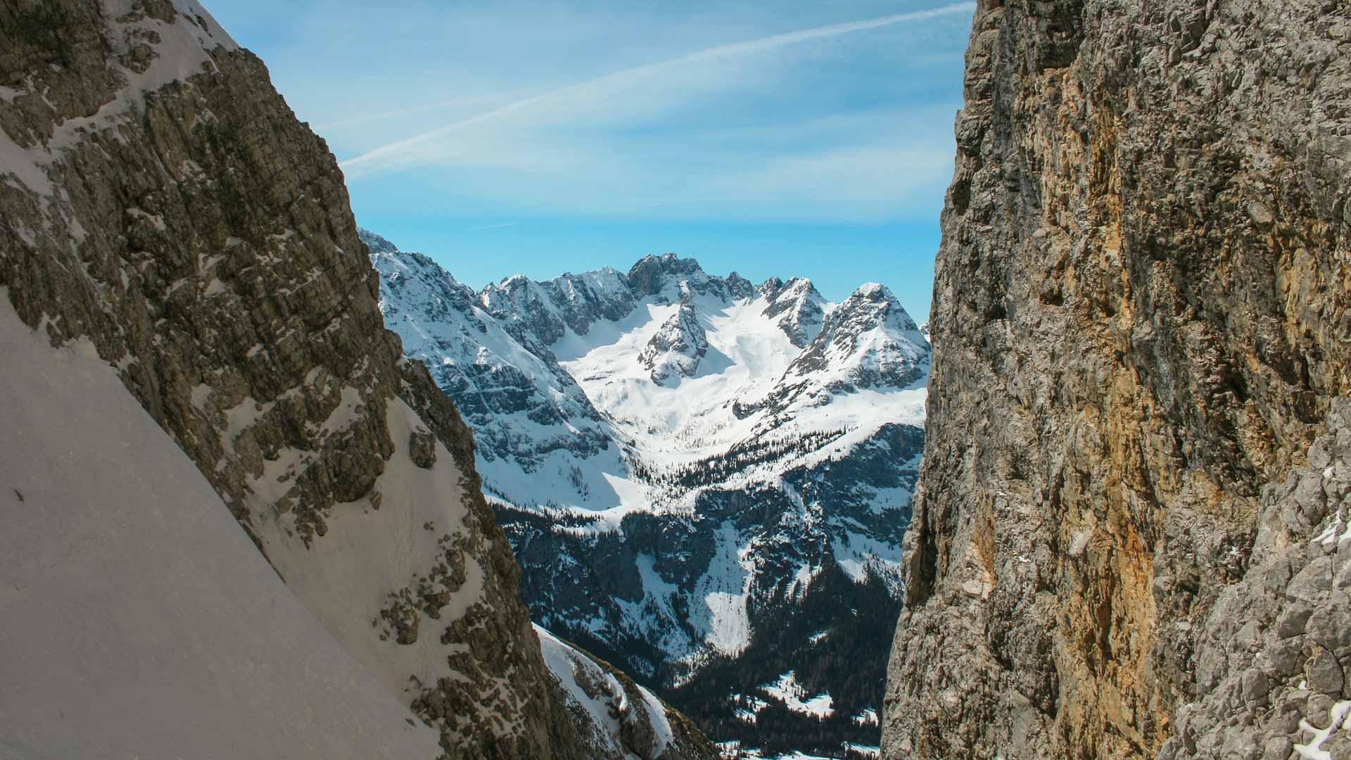 Skitour Zugspitze: Blick durch eine enge Felsschlucht in der Neuen Welt auf schneebedeckte Gipfel und Nadelwälder.