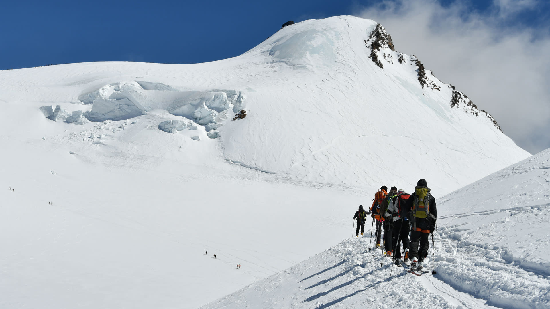 Gruppe von Skitourengehern mit Fellen auf dem Gletscher im Aufstieg zur Cabana Margherita, Seracs-Zone links sichtbar.