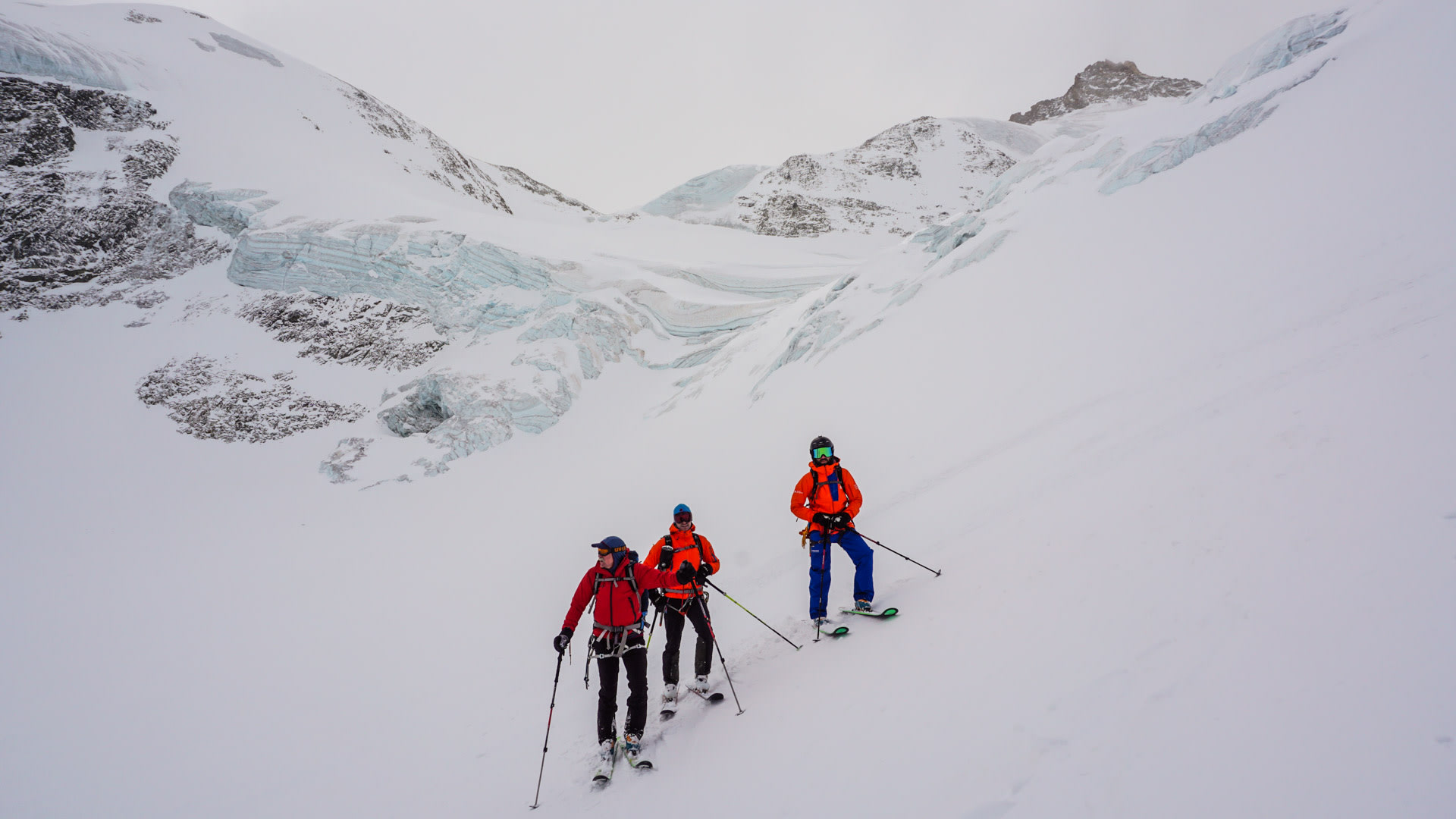 Drei Skitourengeher mit Fellen beim Aufstieg über ein Gletscherfeld mit Seracs in den Walliser Alpen.