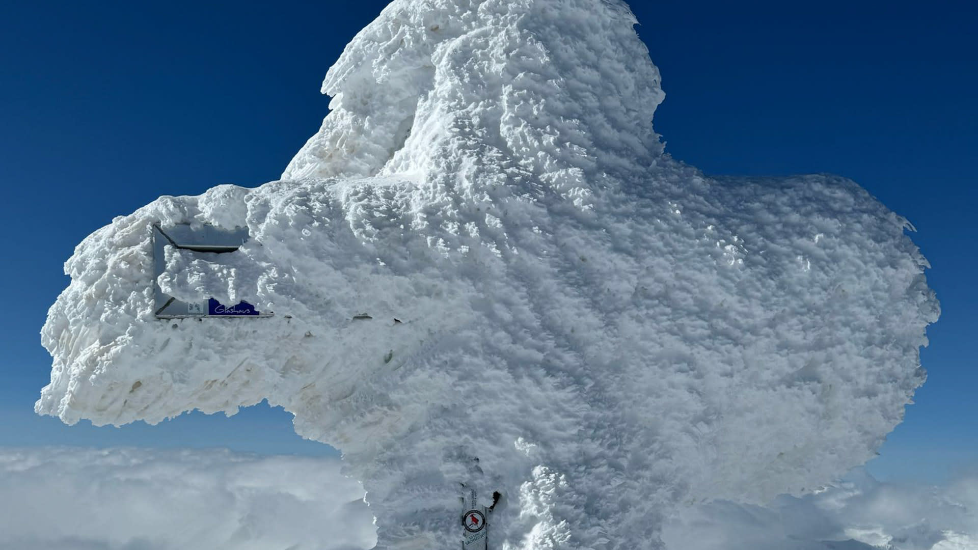 Skitour Grossvenediger: Gipfelkreuz vollständig mit Raureif und Eisablagerungen überzogen, wolkenloser blauer Himmel