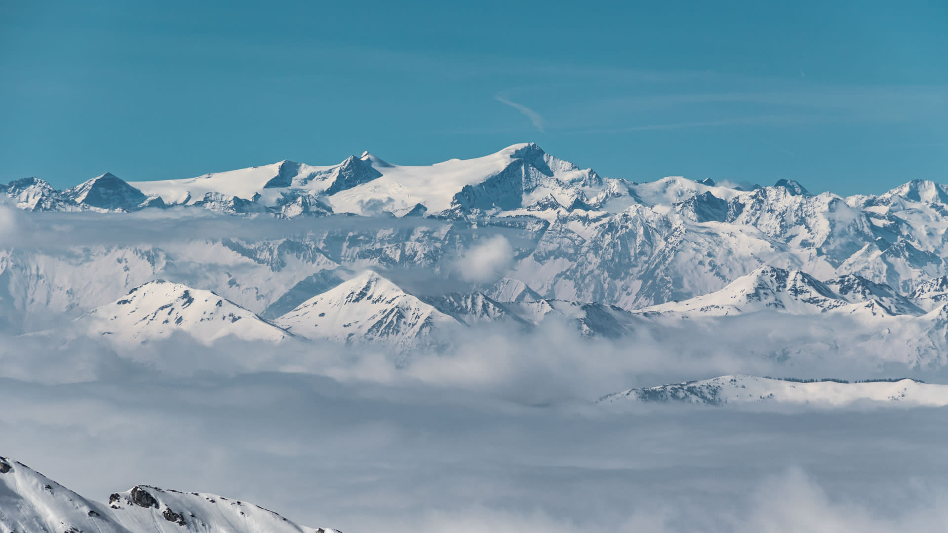Skitour am Grossvenediger: Weitwinkel-Panorama über einer geschlossenen Wolkendecke mit vergletscherten Gipfeln der Ostalpen
