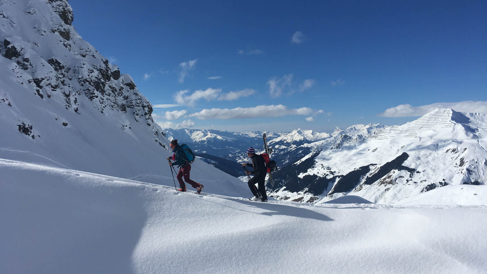 Zwei Freerider steigen mit Skiern und Fellen einen steilen Hang im Wettersteingebirge auf.