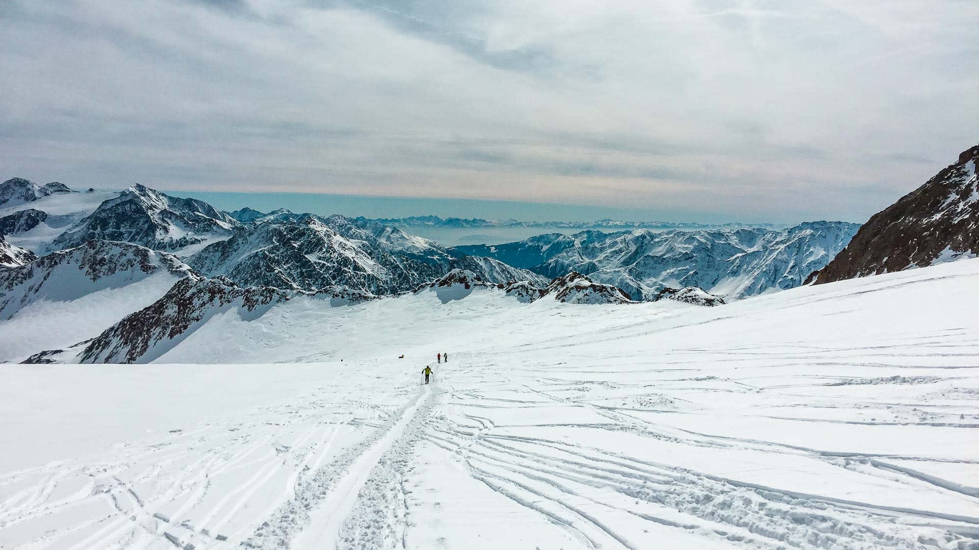 Drei Skitourengeher im Aufstieg über ein fächerartig gespurtes Schneeplateau auf der Venter Runde im Ötztal.