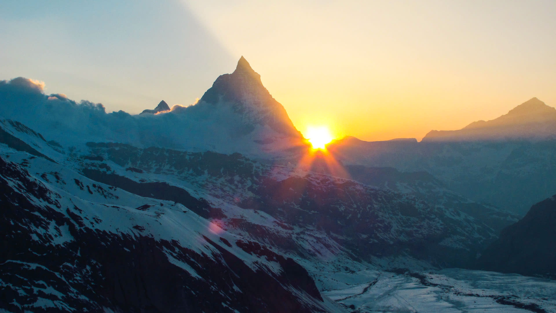 Skitour Dufourspitze: Sonnenaufgang hinter dem Matterhorn mit Sterneffekt, gesehen von der Neuen Monterosa Hütte.