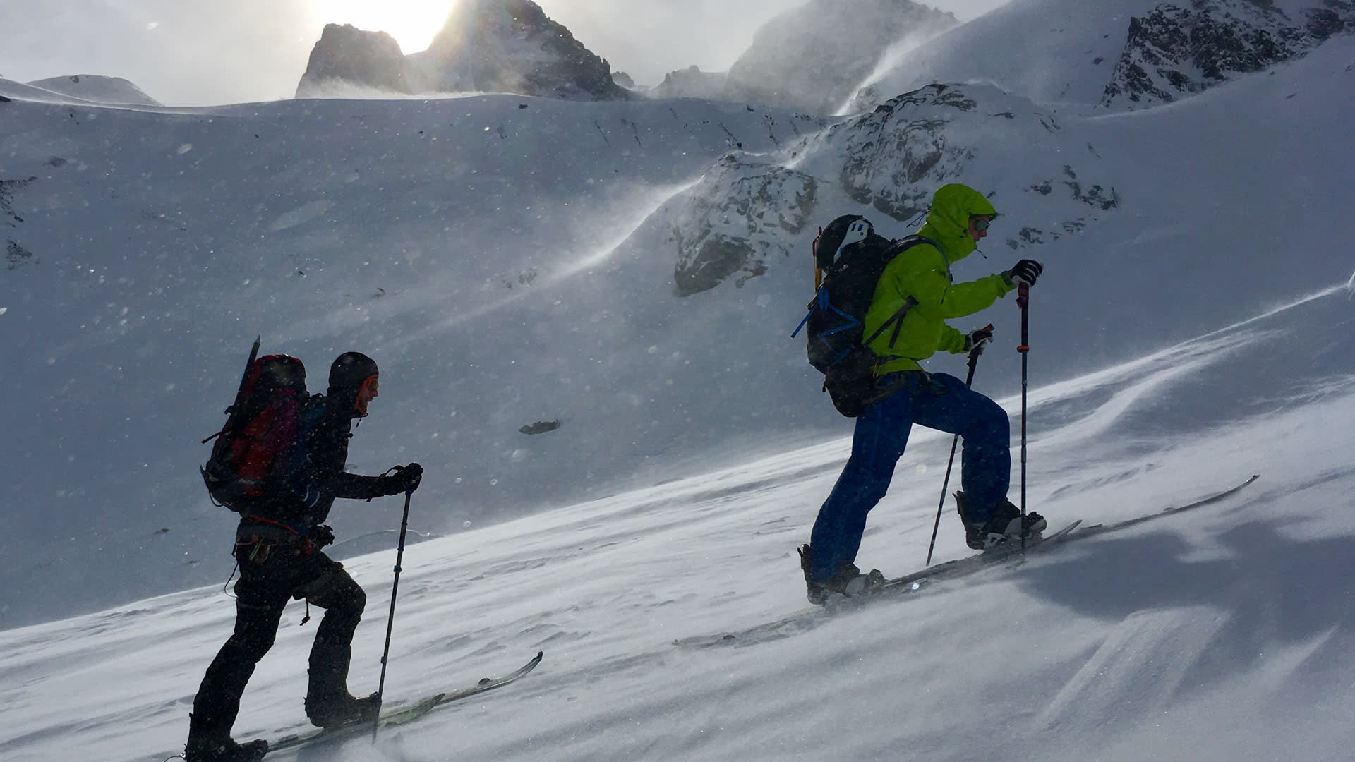 Zwei Freerider beim Splitboard-Aufstieg auf verschneitem Steilhang in der Silvretta mit Fellen und Stöcken.