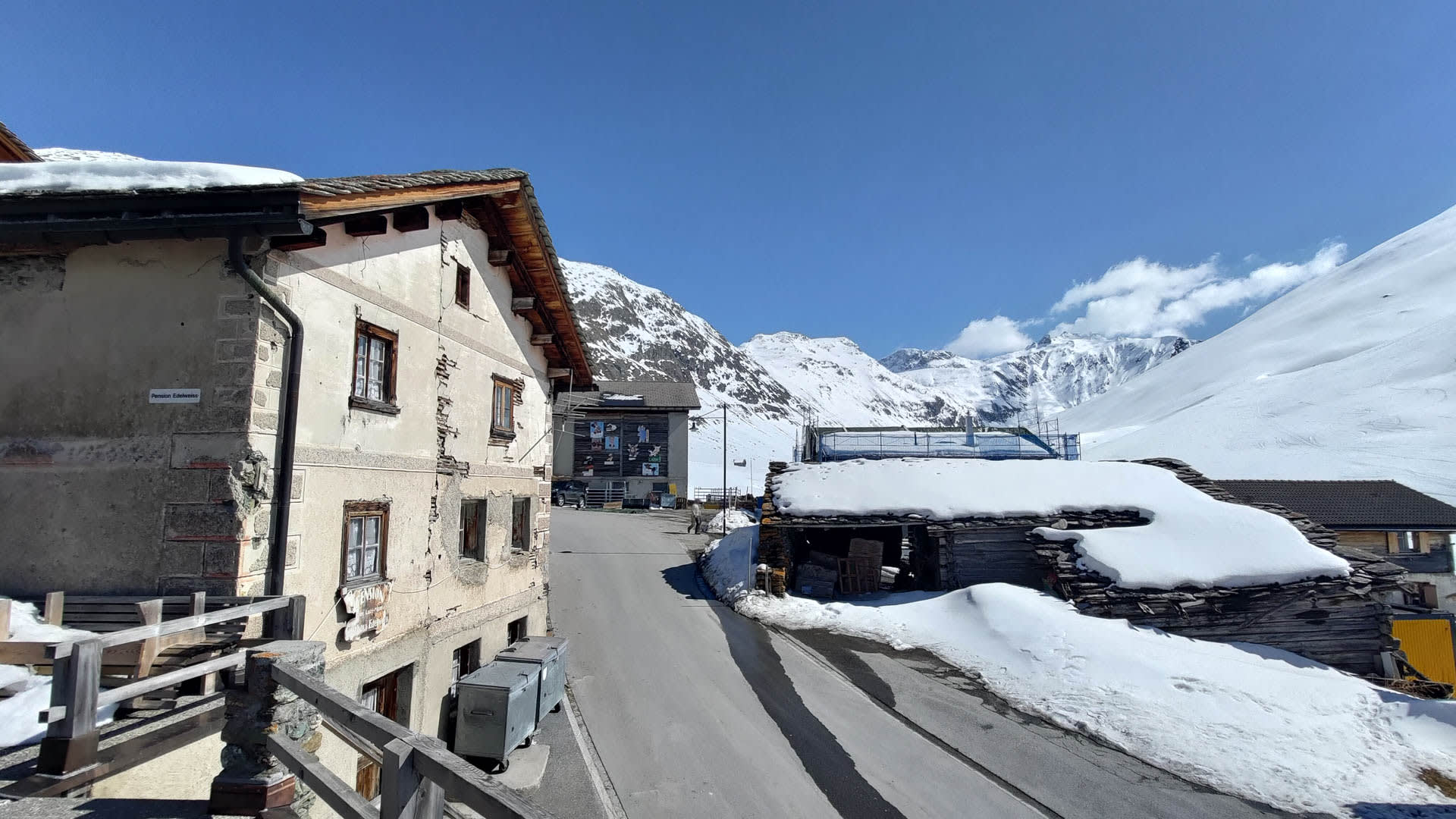 Winterwanderung im Averstal: Blick auf Juf mit Pension Edelweiss, schneebedeckten Dächern, Dorfstraße und verschneiten Berghängen