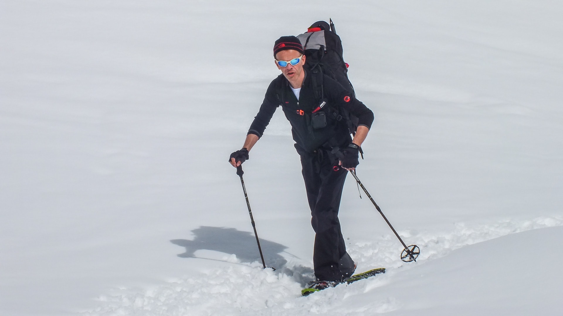 Person mit Tourenski und Rucksack beim Aufstieg auf verschneitem Hang – Winterwanderung in den Berchtesgadener Alpen mit Fellen