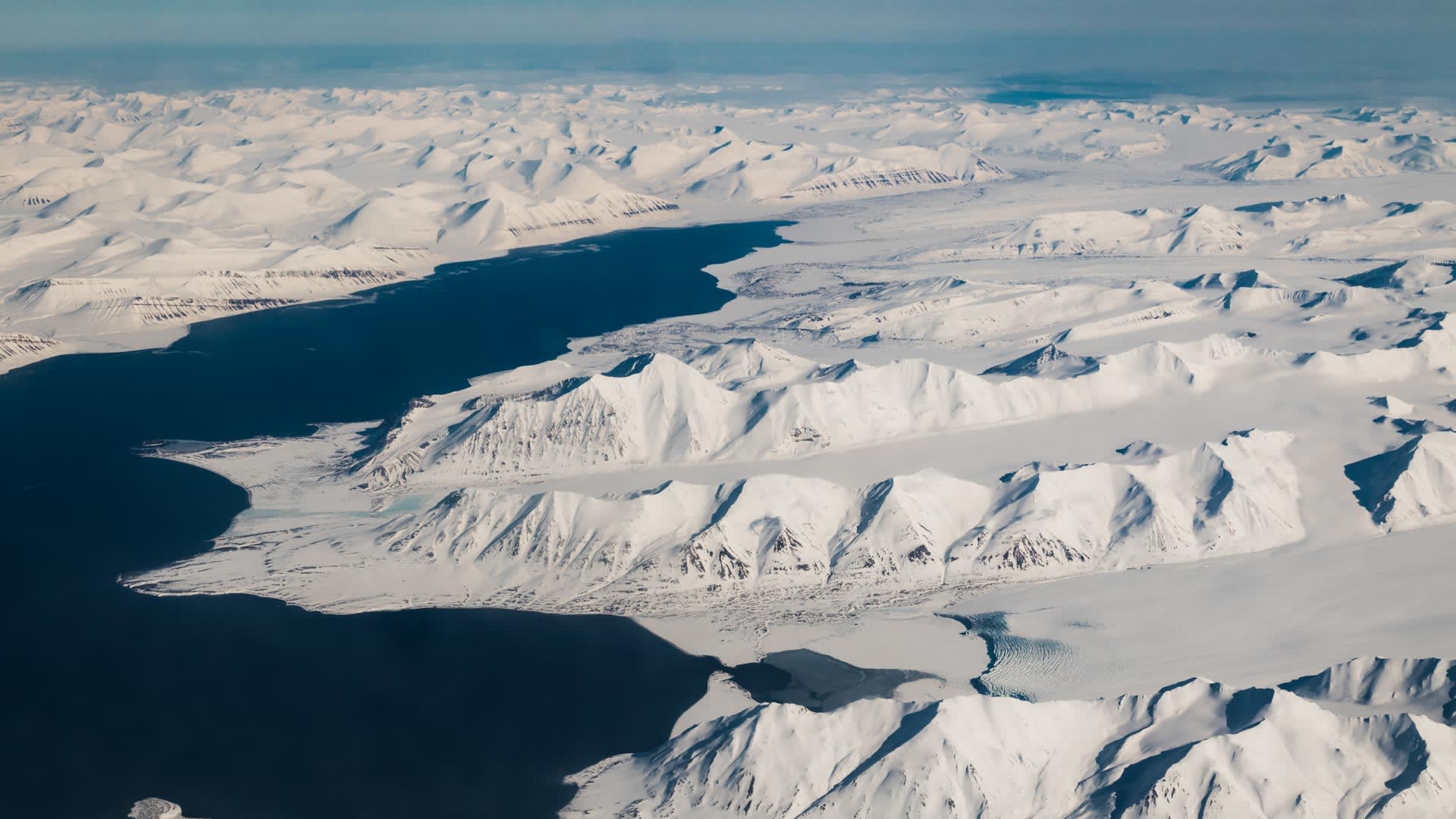 Luftaufnahme der arktischen Fjordlandschaft bei Prins Karl Forland auf Spitzbergen mit schneebedeckten Bergen