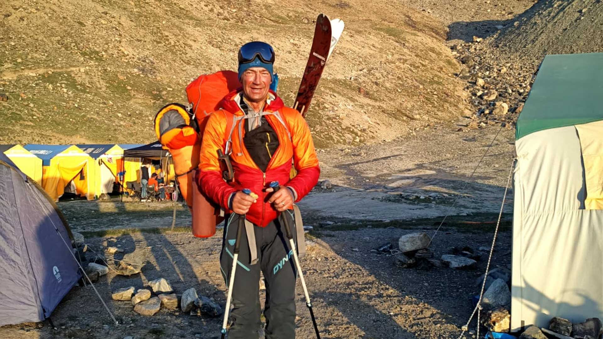 Bergsteiger mit Rossignol-Ski und Dynafit-Rucksack steht nach der erfolgreichen Besteigung aufrecht im Basislager