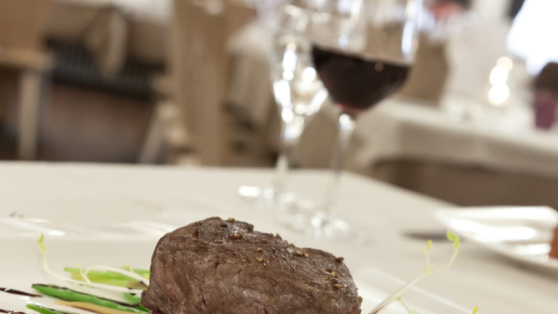 Angerichtetes Fleischgericht mit Rotwein im Restaurant des Hotel Bär & Post Zernez.