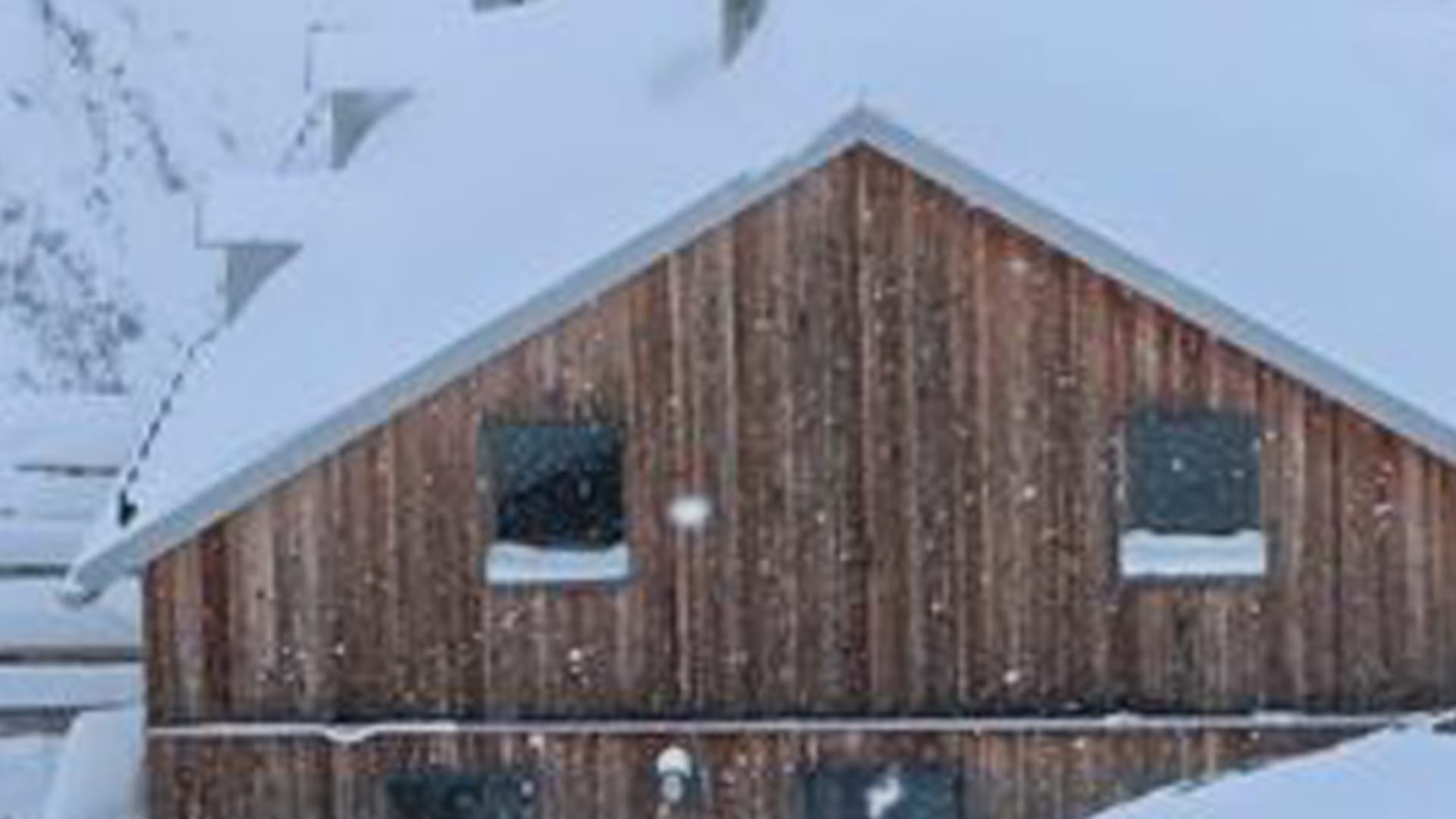 Vogelperspektive der schneebedeckten Chamanna Lischana in winterlicher Graubündner Berglandschaft.