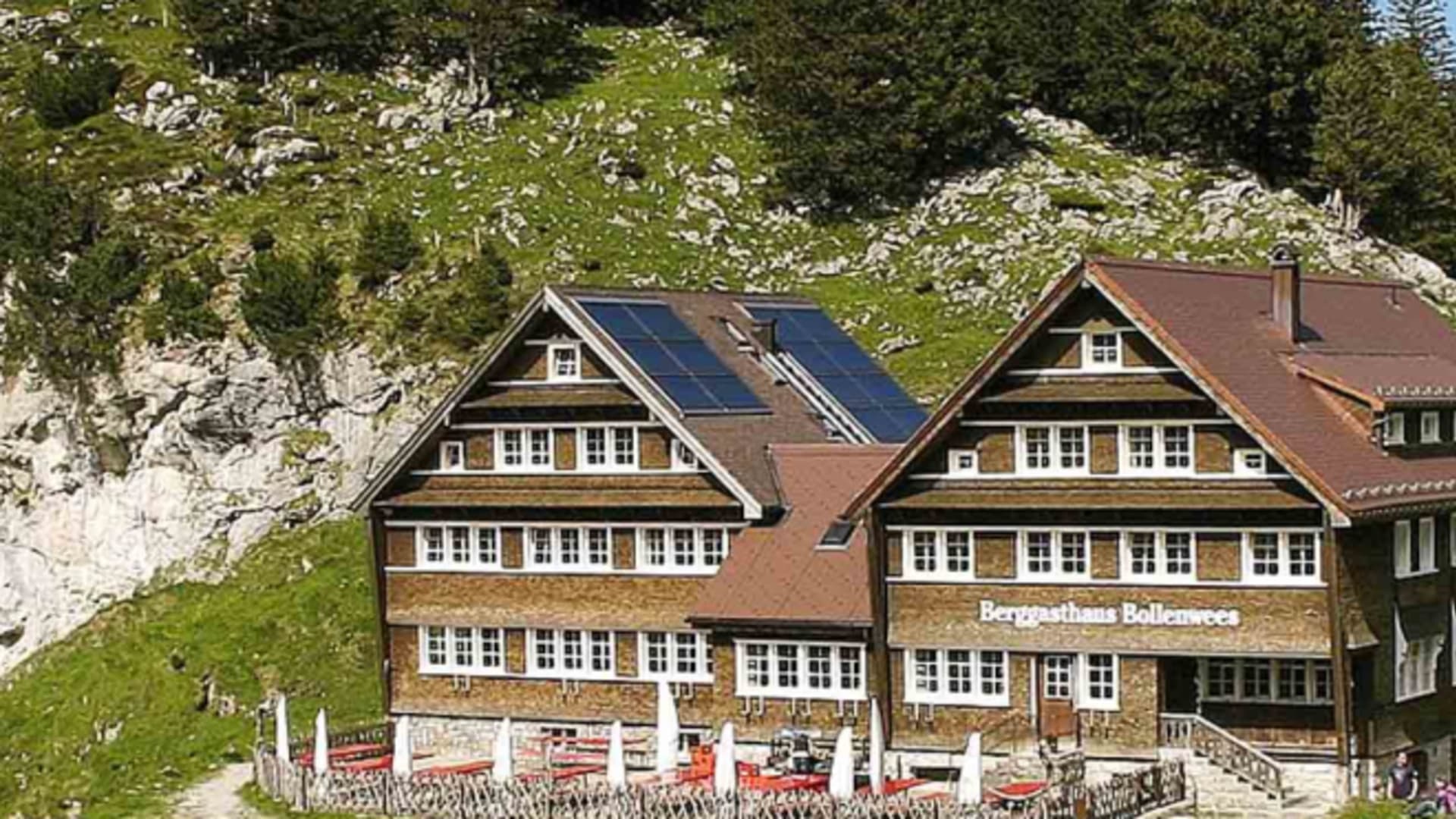 Außenansicht des Berggasthaus Bollenwees mit traditioneller Appenzeller Holzarchitektur und roter Terrasse.